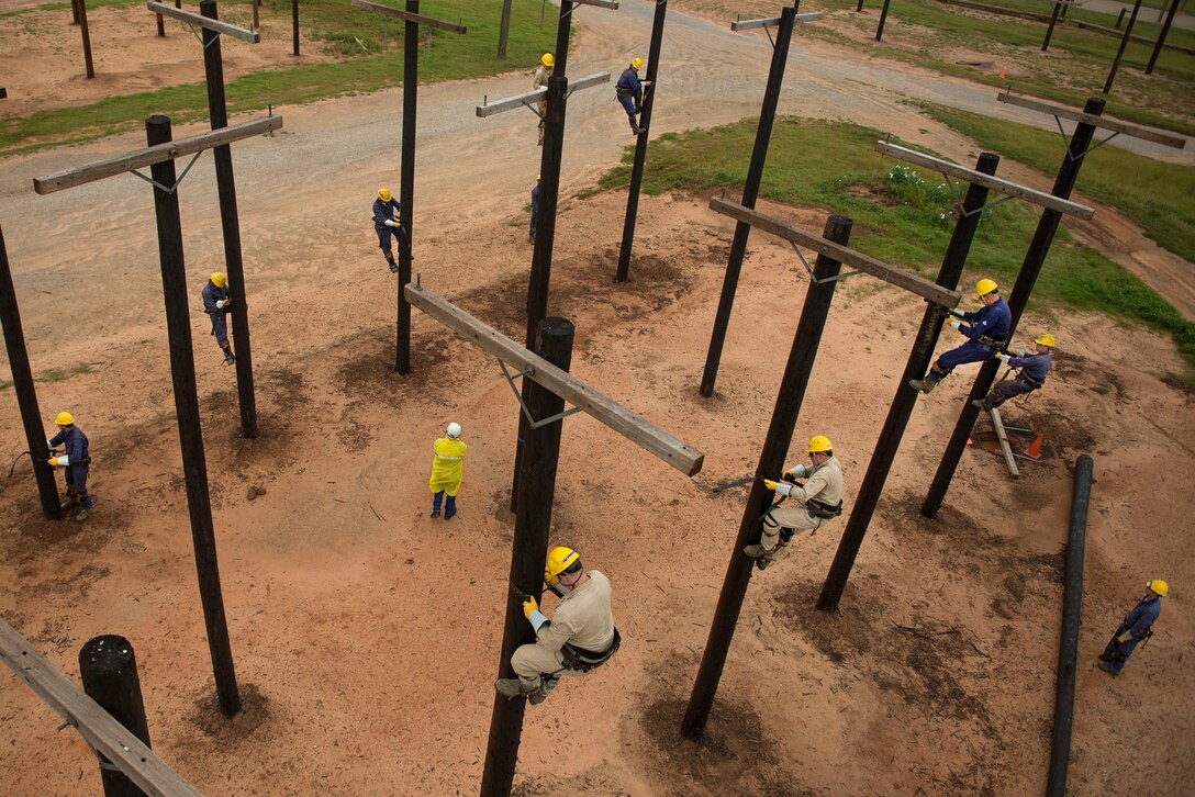 U.S. Air Force Airmen climb utility poles during their training at Sheppard Air Force Base, Texas, May 19, 2015. The electronic systems apprentice or power-line distribution course, teaches students how to use, install and maintain electrical equipment necessary for mission success. (U.S. Air Force photo by Senior Airman Kyle Gese/Released)