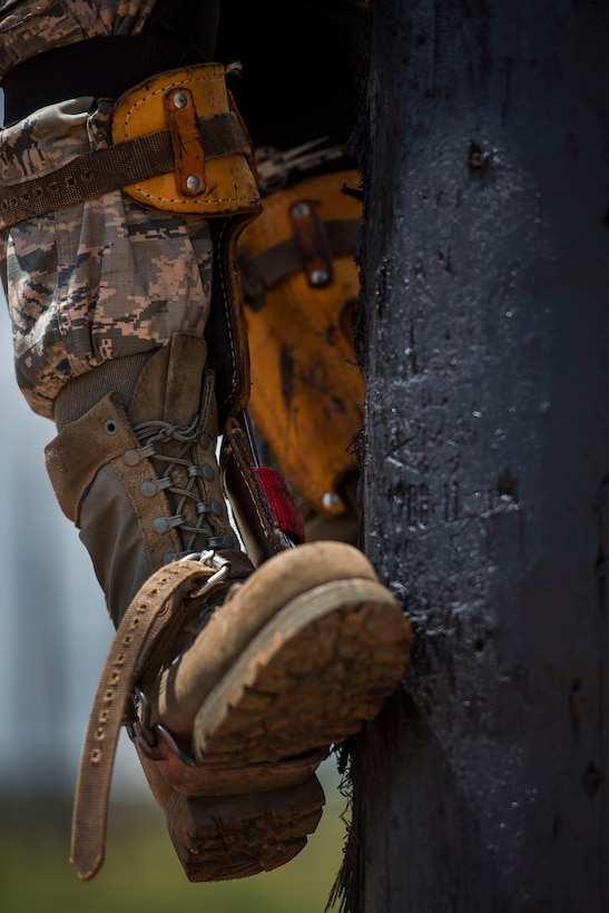 A U.S. Air Force Airman from the 366th Training Squadron, uses climbing spikes to climb a utility pole as part of an electronic systems apprentice training course at Sheppard Air Force Base, Texas, May 18, 2015. In addition to using spikes, students also train while wearing a climbing harness and straps. (U.S. Air Force photo by Senior Airman Kyle Gese/Released)