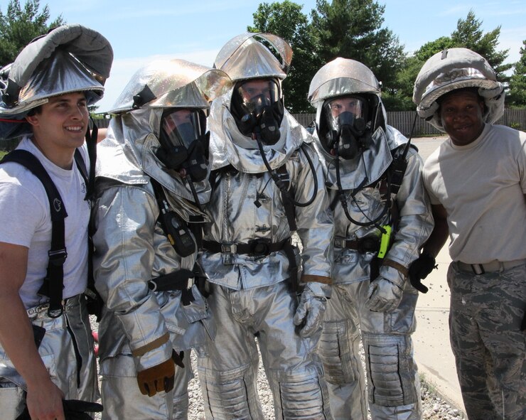 Sweating alongside the unit Airmen is the commander of the 932nd Airlift Wing, Col. Karl Goerke, center, during a specialized training event using fire and water elements to understand what could happen in real world aircraft situations.  The Air Force Reserve Command fire fighters based at Scott worked a full day of drills carrying heavy hoses, moving tanker trucks, driving fire trucks and spraying fires with water.  (U.S. Air Force photo/Maj. Stan Paregien)