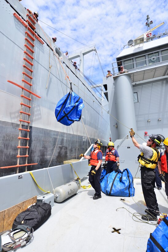 Hampton Roads Marine Firefighting School students hoist equipment to a National Defense Reserve vessel during a maritime incident response exercise at Fort Eustis, Va., May 15, 2015. After transferring equipment to the vessel, the students went through a simulated fire exercise in which they rescued two people from different locations within the ship. (U.S. Air Force photo by Staff Sgt. Natasha Stannard/Released)
