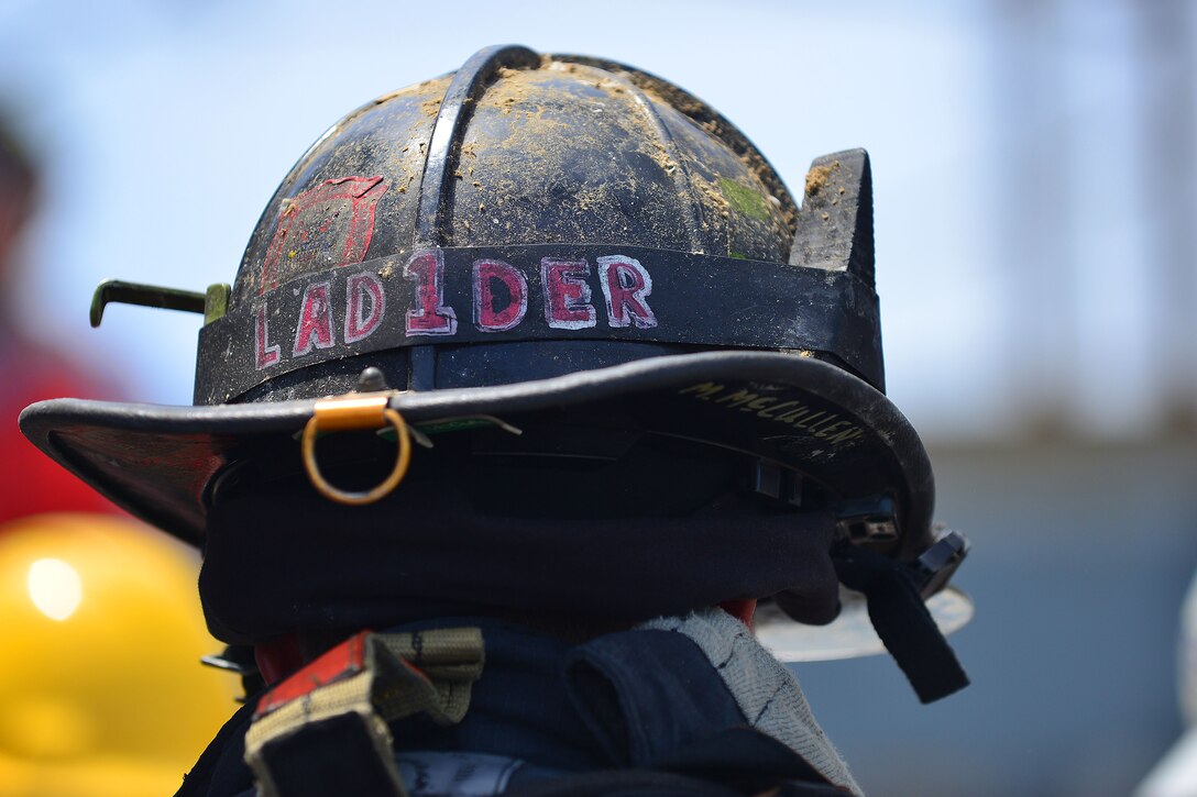 Mike McMullen, City of Hampton fire fighter dons his helmet at the 24th Annual Hampton Roads Marine Firefighting School maritime incident response exercise at Fort Eustis, Va., May 15, 2015. Military and civilian firefighters from around the world participated in the five-day school, which ended with the incident response exercise. (U.S. Air Force photo by Staff Sgt. Natasha Stannard/Released)