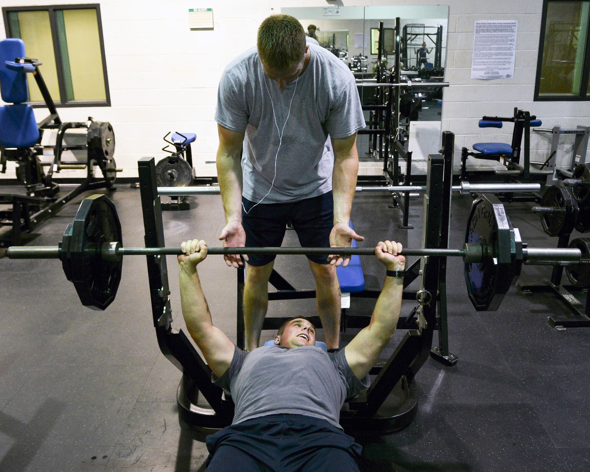 U.S. Air Force Senior Airman Brandon Barksdale, 7th Civil Engineer Squadron firefighter, spots Senior Airman Steven Vermillion, 7th CES firefighter, during a workout May 18, 2015, at Dyess Air Force Base, Texas. The Dyess Fitness Center started a 24-hour fitness program that permits unsupervised facility usage after normal hours of operation. During these hours, the fitness center highly recommends the use of the wingman/buddy concept while working out for safety and accountability. (U.S. Air Force photo by Airman 1st Class Kedesha Pennant/Released)