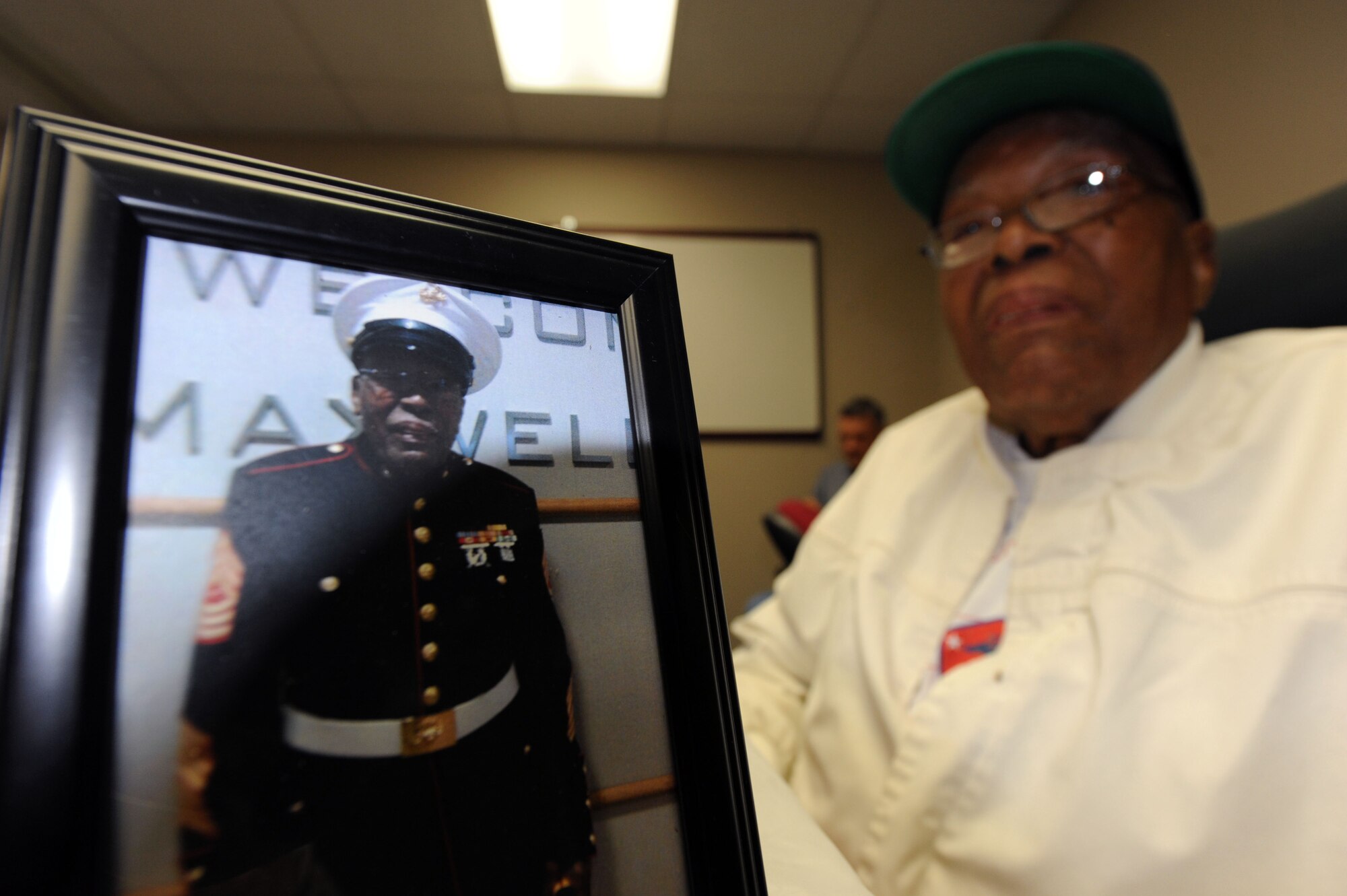 Retired Marine Corps Master Sgt. Thomas Davis displays a younger image of himself during his 95th birthday party held at the fitness and wellness center on Maxwell Air Force Base, Alabama, May 15, 2015. Davis is a Pearl Harbor survivor who served 10 years in the Navy before joining the Marine Corps for an additional 30 years (1939-1968). (U.S. Air Force photo by Airman 1st Class Alexa Culbert)