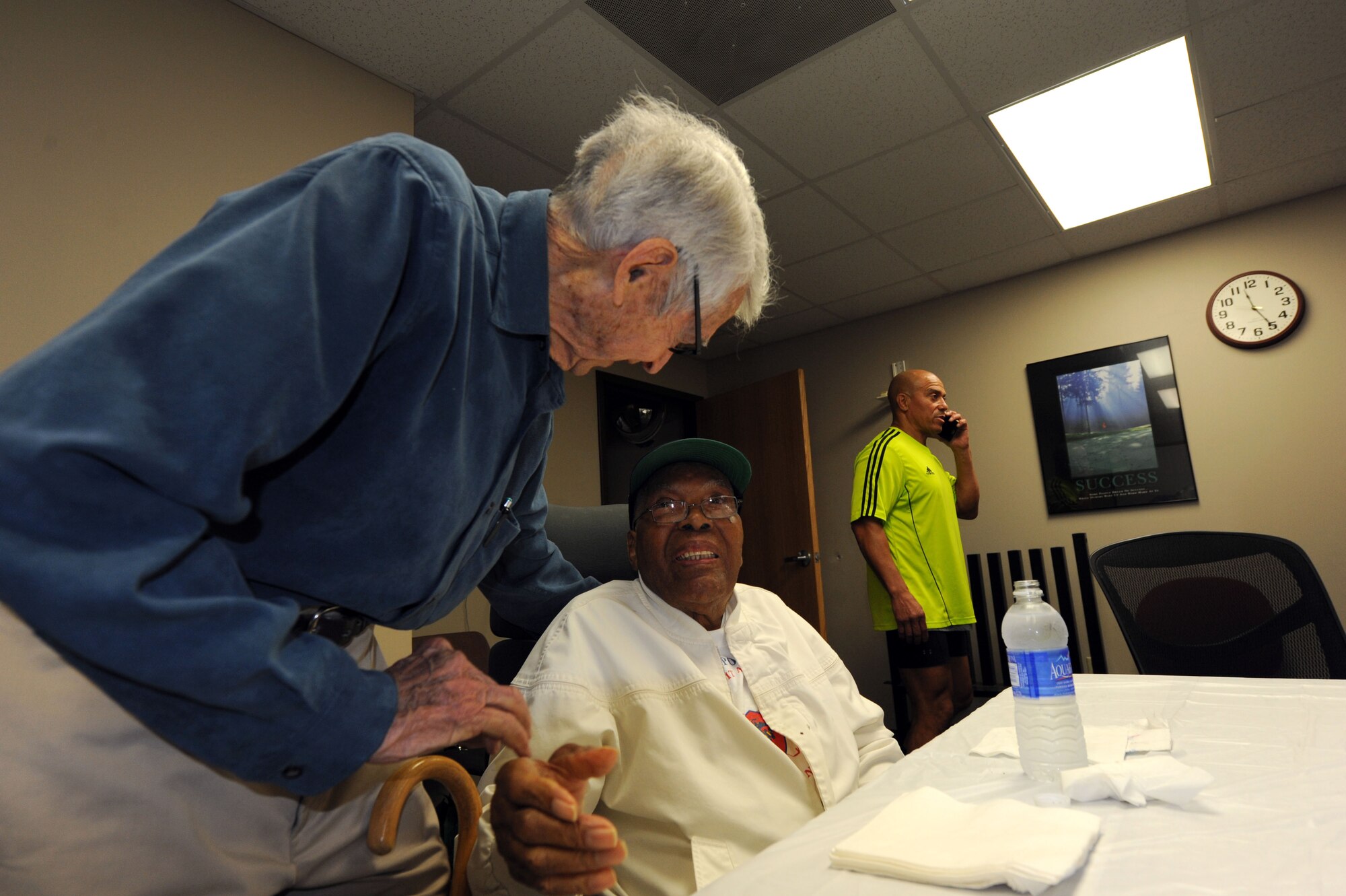 Retired Air Force Lt. Col. Al Carroll (left), and former Marine, wishes retired Marine Corps Master Sgt. Thomas Davis a happy birthday during his 95th birthday party at the fitness and wellness center, Maxwell Air Force Base, Alabama, May 15, 2015. The fellow Marines met at the Fitness and Wellness Center 40 years ago and have been friends ever since. (U.S. Air Force photo by Airman 1st Class Alexa Culbert)