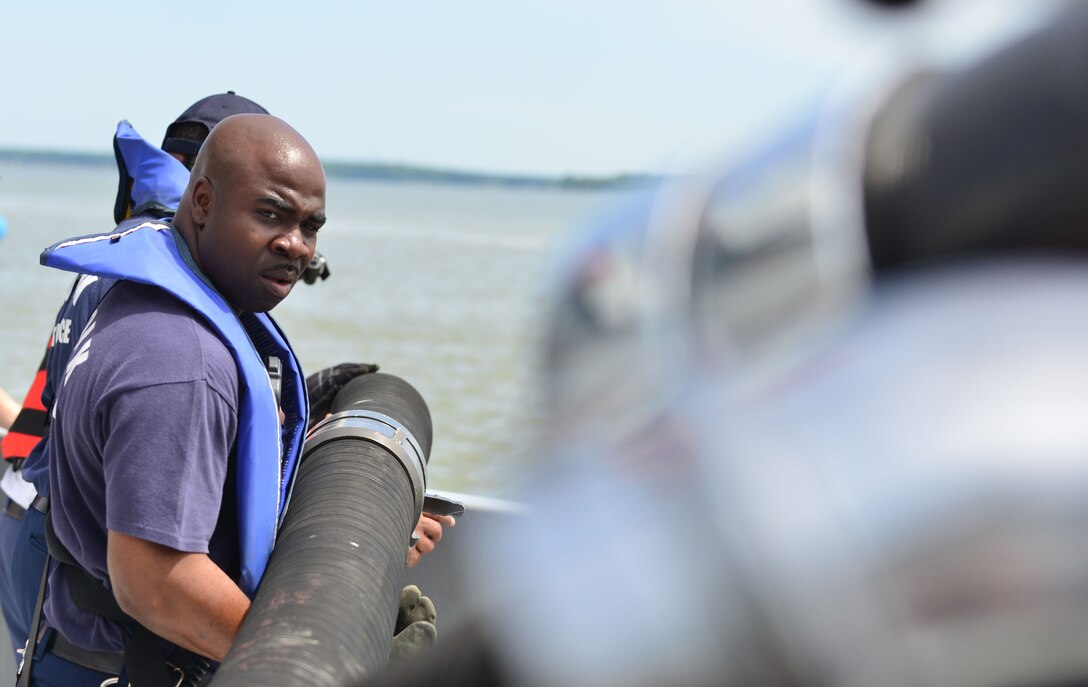 Derrick Hall, Norfolk Fire Rescue firefighter, sets up equipment for the capstone exercise of the 24th Annual Hampton Roads Marine Firefighting School at Fort Eustis, Va., May 15, 2015. The capstone tested maritime incident procedures including logistics, command and control, response and rescue. (U.S. Air Force photo by Staff Sgt. Natasha Stannard/Released)