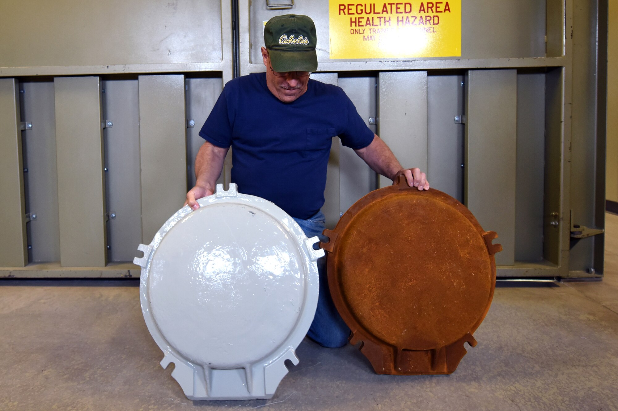 Bob Hassell, 341st Missile Maintenance Squadron corrosion shop mechanic, shows the comparison of a heavily corroded vault cover versus a finished product May 15, 2014, at Malmstrom Air Force Base, Mont. The technicians conduct periodic maintenance inspections and perform corrosion control work to sustain launch and missile alert facilities.  (U.S. Air Force photo/Chris Willis)