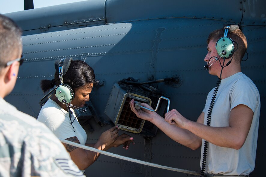 U.S. Air Force Tech. Sgt. Zachary Marquis, 41st Helicopter Maintenance Unit loading station crew member, evaluates Staff Sgt. Tameka Lindsay, 41st HMU load crew chief, middle, and Senior Airman Cleveland Green, 41st HMU weapons load team member, during the 23d Wing weapons load competition May 18, 2015, at Moody Air Force Base, Ga. A team of evaluators traveled to Davis-Monthan AFB, Ariz., and Nellis AFB, Nev., to judge the 23d Wing’s geographically separated squadrons battling in the competition. (U.S. Air Force photo by Airman 1st Class Ceaira Tinsley/Released)