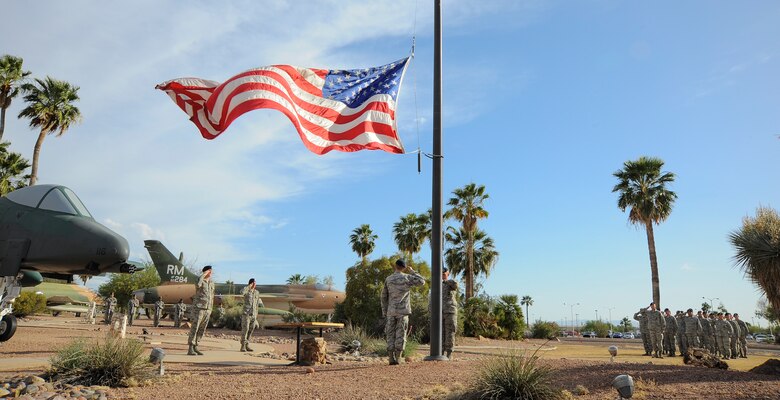 Airmen from the 355th Security Forces Squadron lower the American flag during a retreat ceremony for National Police Week at Davis-Monthan Air Force Base, Ariz., May 14, 2015. The retreat ceremony honored security forces and law enforcement members who have died in the line of duty. (U.S. Air Force photo by Staff Sgt. Angela Ruiz/released)