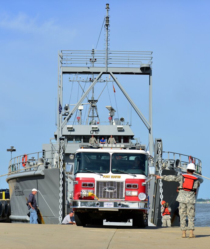 U.S. Army Staff Sgt. Rosado Harcel, 97th Transportation Brigade (Heavy Boat) Bristoe Station boatswain, guides a Joint Base Langley-Eustis fire truck onto the Bristoe Station during the 24th Annual Hampton Roads Marine Firefighting School maritime incident response exercise at Fort Eustis, Va., May 15, 2015. The Bristoe Station crew transported the firefighters and their equipment to the exercise location on A U.S. Department of Transportation Maritime Administration (MARAD) National Defense Reserve vessel. (U.S. Air Force photo by Staff Sgt. Natasha Stannard/Released)