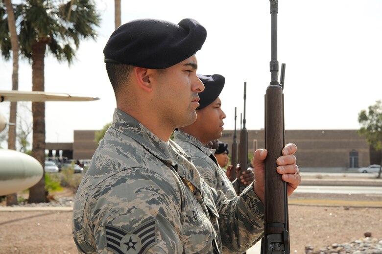 U.S. Air Force Staff Sgt. Michael Doria, 355th Security Forces Squadron confinement NCO, stands at attention after a 3-volley rifle salute during a retreat ceremony for National Police Week at Davis-Monthan Air Force Base, Ariz., May 14, 2015. A retreat ceremony is a military tradition that serves two purposes: to signal the end of the official duty day and serve as a ceremony for paying respect to the American flag. (U.S. Air Force photo by Staff Sgt. Angela Ruiz/released)