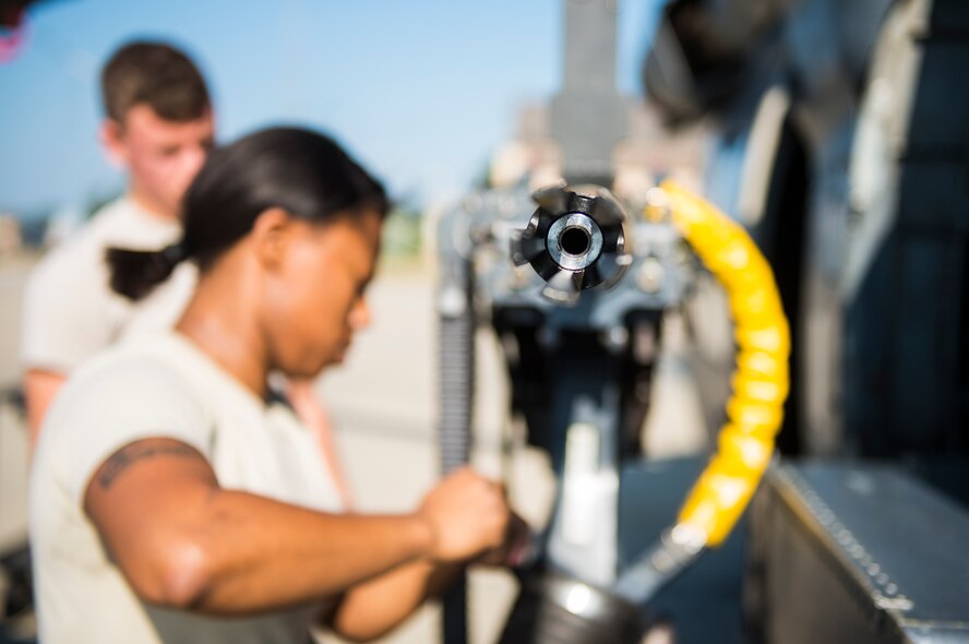 U.S. Air Force Staff Sgt. Tameka Lindsay, 41st Helicopter Maintenance Unit load crew chief, and Senior Airman Cleveland Green, 41st HMU weapons load team member, compete in the 23d Wing weapons load competition May 18, 2015, at Moody Air Force Base, Ga. Green and Lindsay performed as a two-man team to load the GAU 18, a .50-caliber machine gun and a flare magazine onto an HH-60G Pave Hawk. (U.S. Air Force photo by Airman 1st Class Ceaira Tinsley/Released)