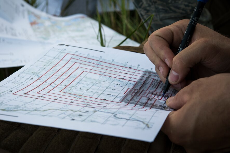 An Airman from the 93d Air Ground Operations Wing plots points on a map as a part of the land navigation event during Spartan Warrior May 12, 2015, at Avon Park Air Force Range, Fla. Each team was given a grid map and had to find as many points as they could within three hours. (U.S. Air Force photo by Senior Airman Ryan Callaghan/Released)