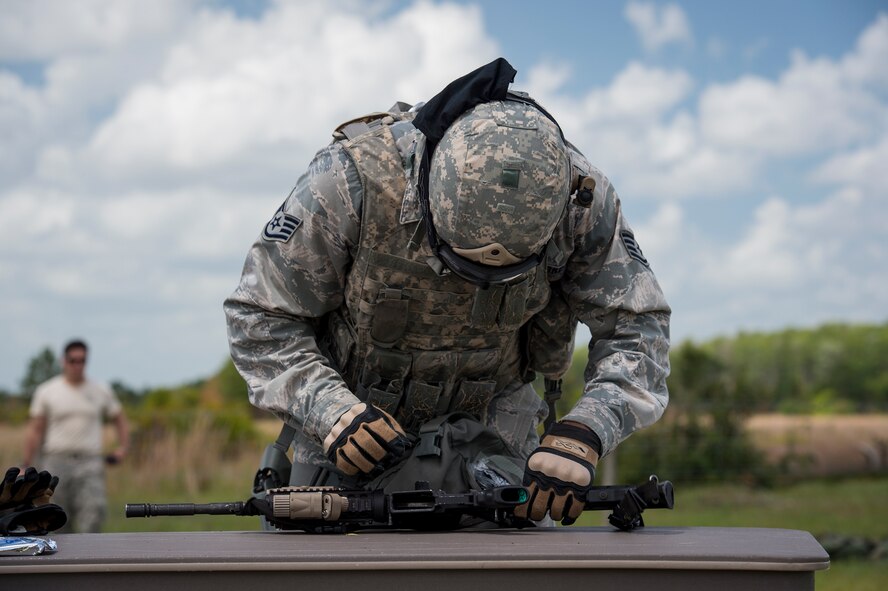 An Airman from the 93d Air Ground Operations Wing begins to tear-down an M4 Carbine as part of a fireteam relay race during Spartan Warrior May 12, 2015, at Avon Park Air Force Range, Fla. Fireteam members had to disassemble and reassemble both the M4 and the M9 Berreta pistol as a part of the obstacle course event. (U.S. Air Force photo by Senior Airman Ryan Callaghan/Released)
