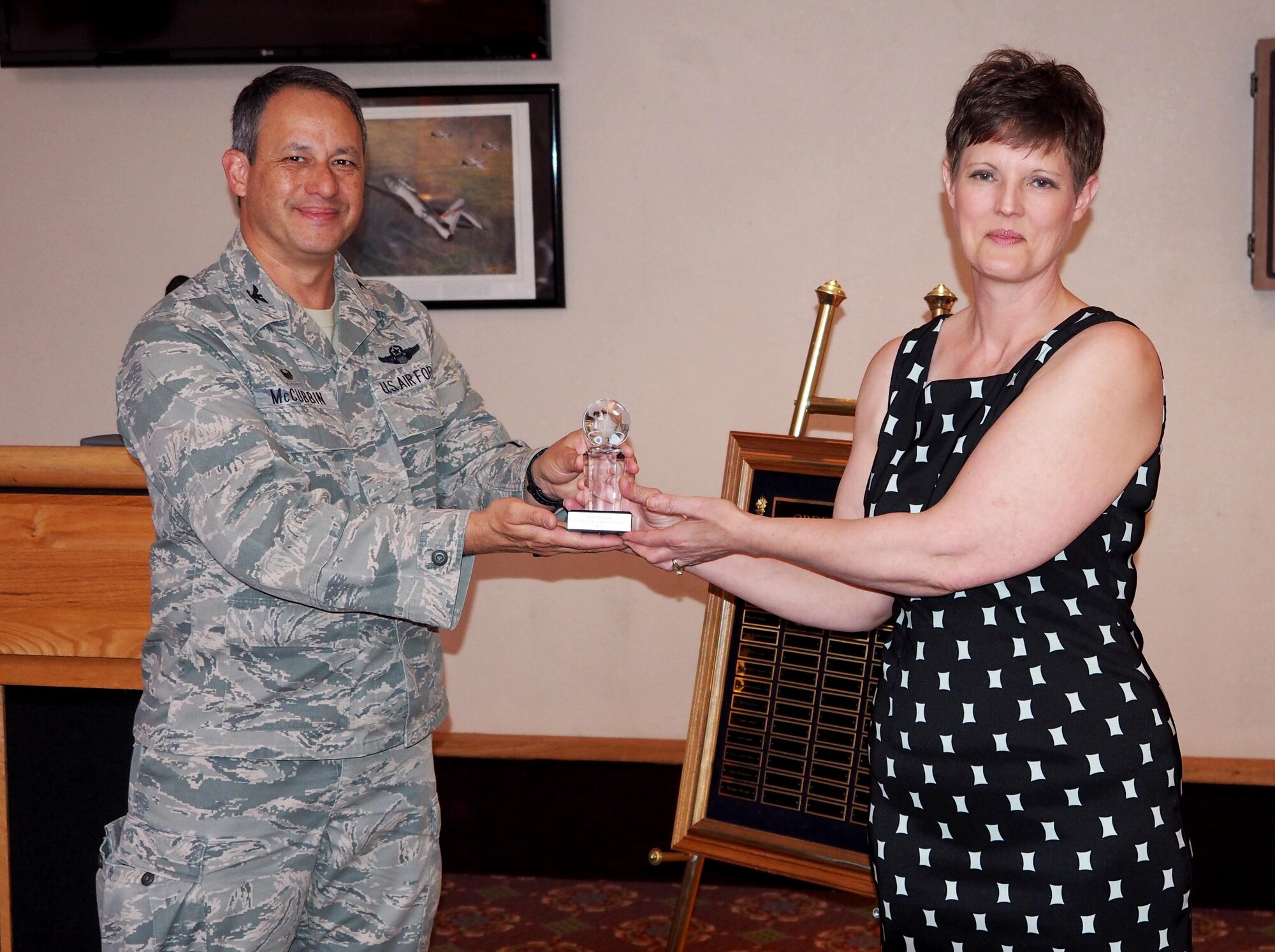 Col. Todd J. McCubbin, 934th Airlift Wing commander, presents Tina Harstad with the crystal globe trophy inducting her into the Order of the Global Vikings May 6. (Air Force Photo/Paul Zadach)