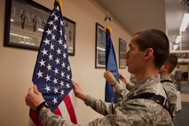 Airman Adrian Sahagun, a member of the 5th Maintenance Squadron, straightens the American flag during an Honor Guard training routine at Minot Air Force Base, N.D., May 14, 2015. Honor Guard teaches Airmen attention to detail from uniforms to folding the American flag. (U.S. Air Force photo/Airman 1st Class Christian Sullivan)