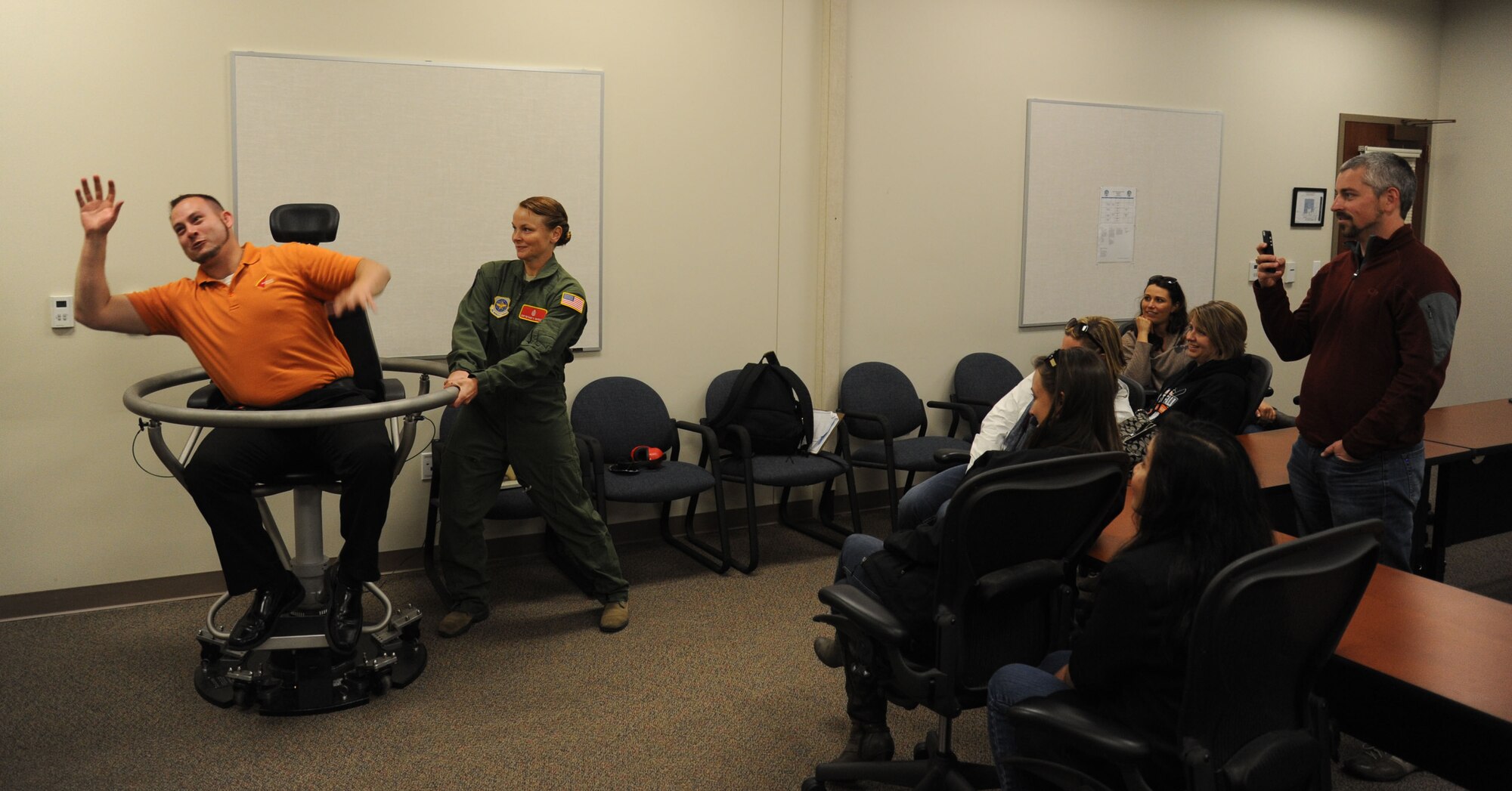 Staff Sgt. Bethany Whiteley, 92nd Aerospace Medicine Squadron aerospace and operational physiology craftsman, shows members of Leadership Spokane the effects of Bárány chair training during a tour May 15, 2015, at Fairchild Air Force Base, Wash. The students had the opportunity to see what it would be like to be a pilot and endure high speeds in the air. (U.S. Air Force photo/Senior Airman Sam Fogleman)