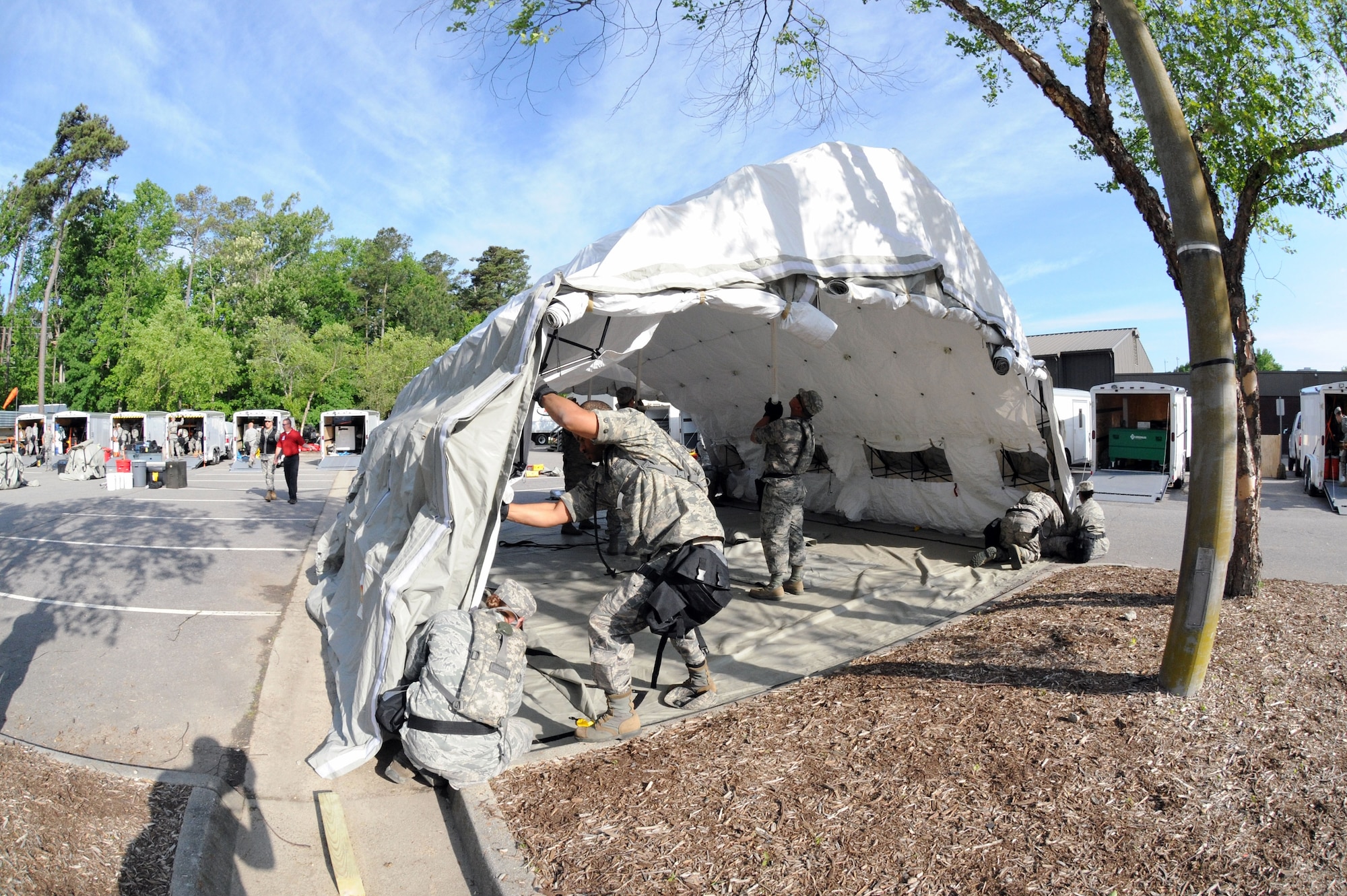 Members of the 113th Wing, D.C. Air National Guard, Fatality Search and Recovery Team put up a tent during Chemical Biological Radiological Nuclear (CBRN) Emergency Response Force Package training, May 14, 2015 in Virginia Beach, Va.  (U.S. Air National Guard photo by Airman 1st Class Anthony Small)