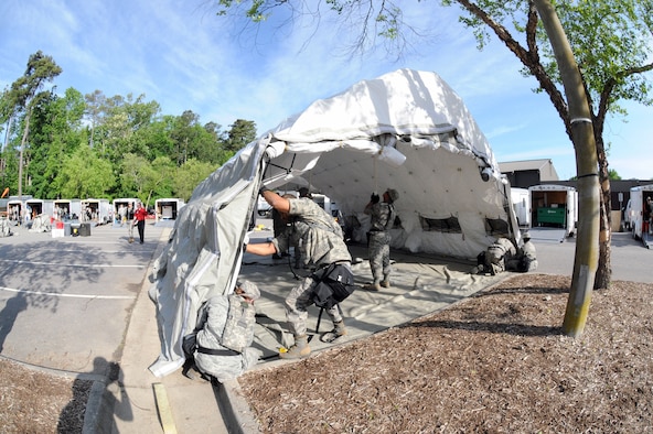 Members of the 113th Wing, D.C. Air National Guard, Fatality Search and Recovery Team put up a tent during Chemical Biological Radiological Nuclear (CBRN) Emergency Response Force Package training, May 14, 2015 in Virginia Beach, Va.  (U.S. Air National Guard photo by Airman 1st Class Anthony Small)