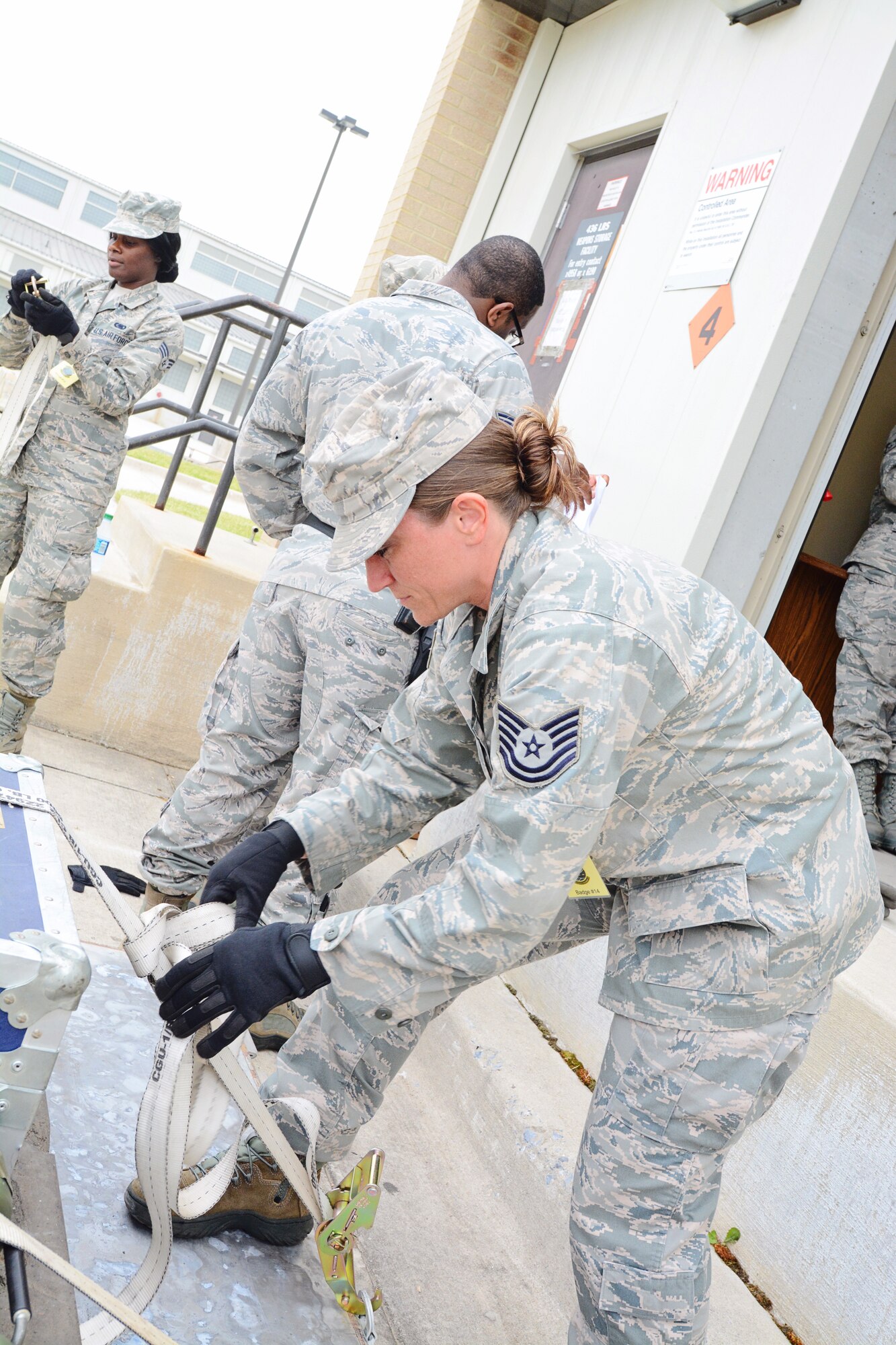 Tech. Sgt. Andrea DelRe, 512th Logistics Readiness Squadron, tightens a strap to secure baggage on a pallet as part of a deployment exercise May 17, 2015, at Dover Air Force Base, Del. A sampling of about 60 wing reservists processed through a mock mobility line, which included checking personal and professional gear. (U.S. Air Force photo/Staff Sgt. Mercedes Crossland)