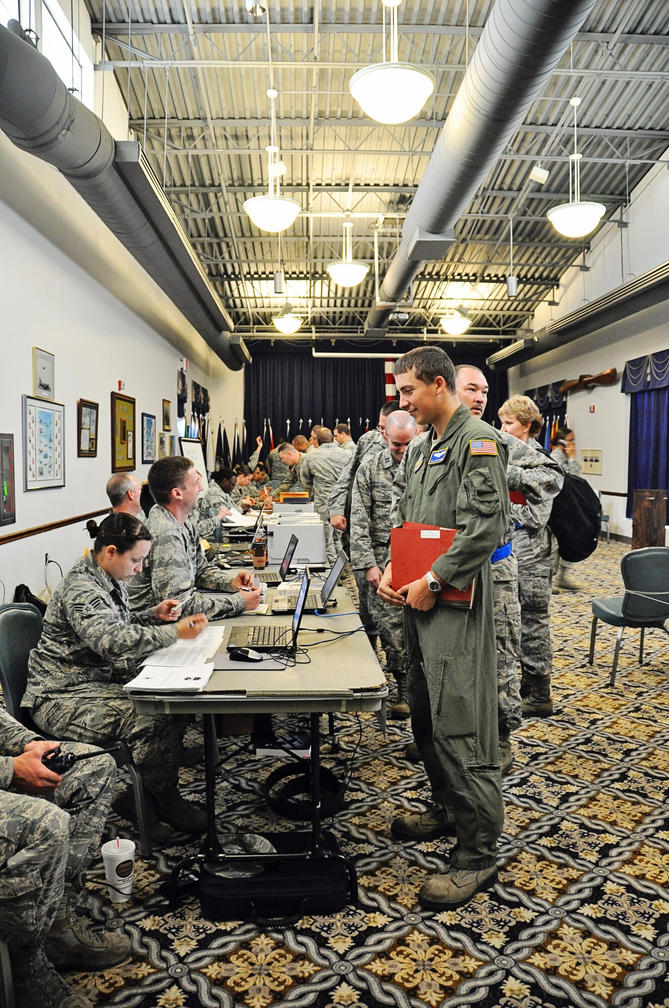 Representatives from 512th Airlift Wing agencies man a mobility line May 17, 2015, on Dover Air Force Base, Del., to verify various medical and administrative requirements for a team of simulated deployers as part of a deployment exercise. Some of the items the Personnel Deployment Function checked for the reservists included dog tags, wills and financial affairs. (U.S. Air Force photo/Master Sgt. Veronica Aceveda)