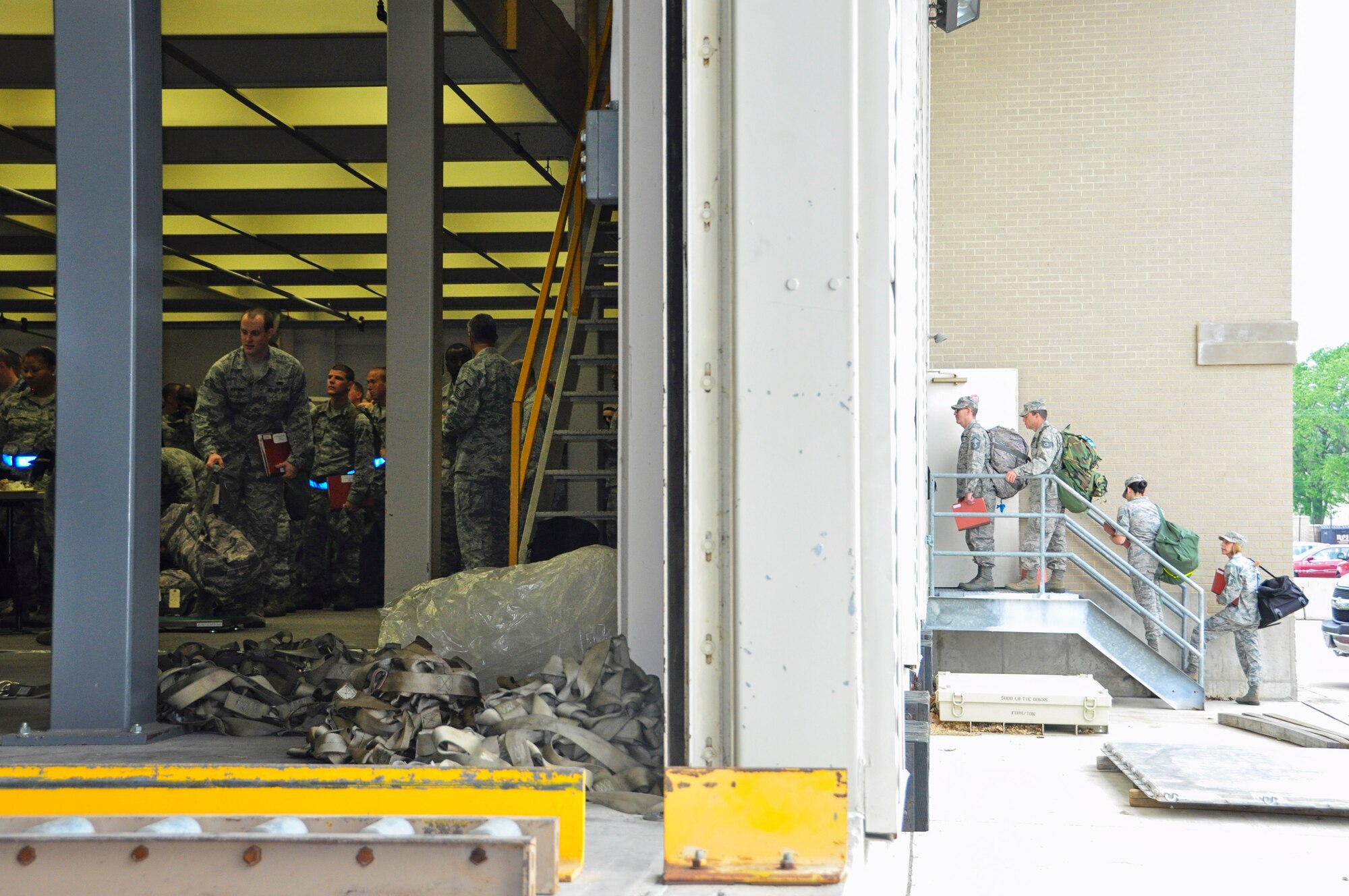 Airmen from the 512th Airlift Wing wait to enter the Mobility Processing Center May 17, 2015, as part of a deployment exercise on Dover Air Force Base, Del. Rehearsing mobility procedures ensures the Reserve wing’s capability to process mass groups of deploying Airmen correctly and efficiently. (U.S. Air Force photo/Master Sgt. Veronica Aceveda)