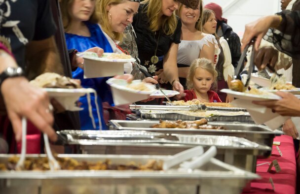 People line up to serve themselves at an open buffet after the initial Peace Carvin V celebration at Mountain Home Air Force Base, Idaho, May 15, 2015. Numerous pirate-themed and traditional Singaporean dishes were featured, cooked by members of the Singaporean community here on base. (U.S. Air Force photo by 2nd LT. Kippun D. Sumner/RELEASED)
