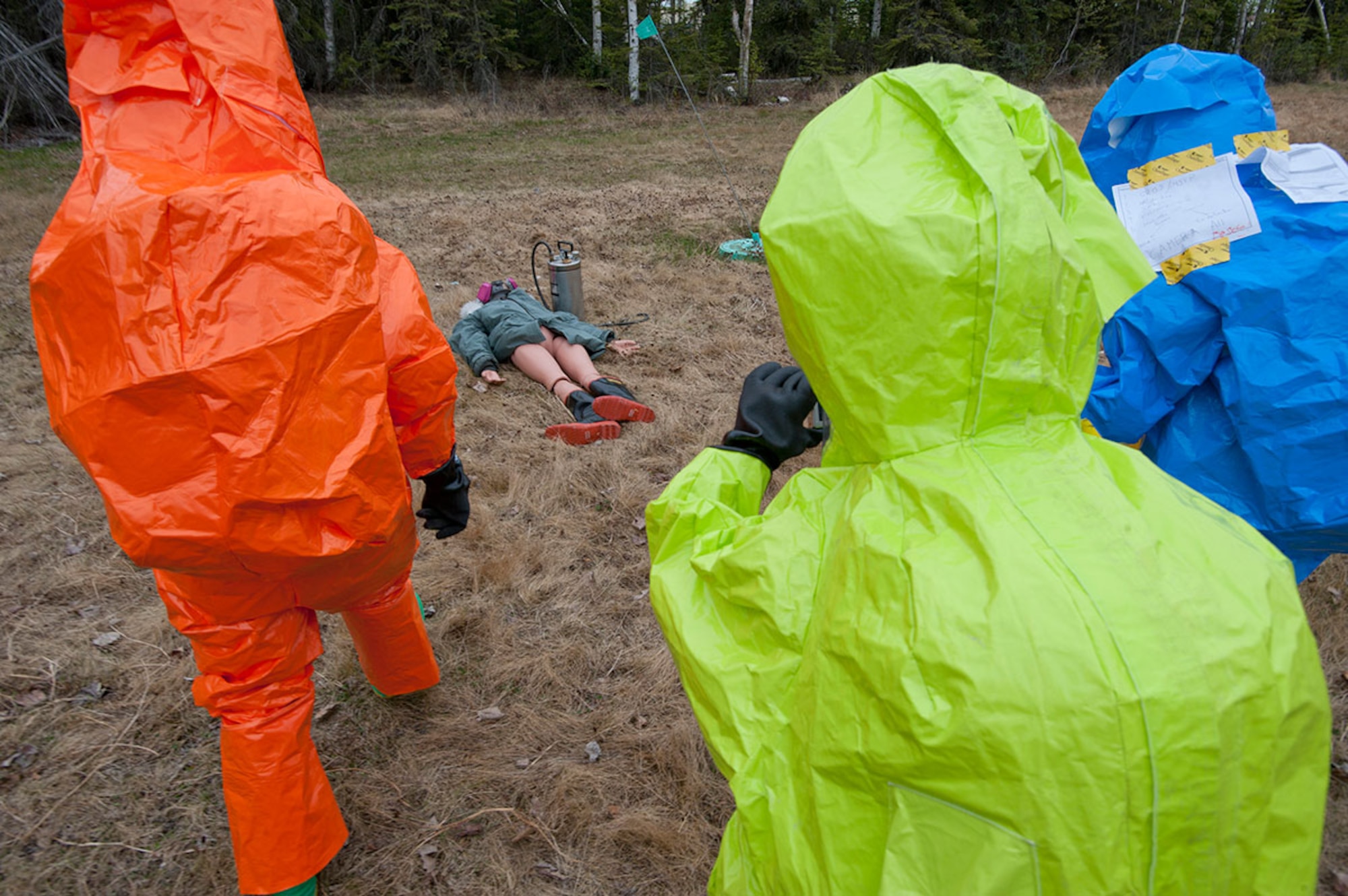 Air National Guard Staff Sgt. James Mainolfi, left, Senior Airman Alex Liccione, center, and Senior Airman Matthew Castellanos approach a simulated body during Integrated Base Emergency Response Training on Joint Base Elmendorf-Richardson, Alaska, May 14, 2015. The scenario involved a deployed environment in which a foreign national was spraying unidentified chemicals on an American installation, and was killed upon confrontation with military police, leaving the chemicals to be identified and responded to accordingly. (U.S. Air Force photo/Tech. Sgt. Robert Barnett)