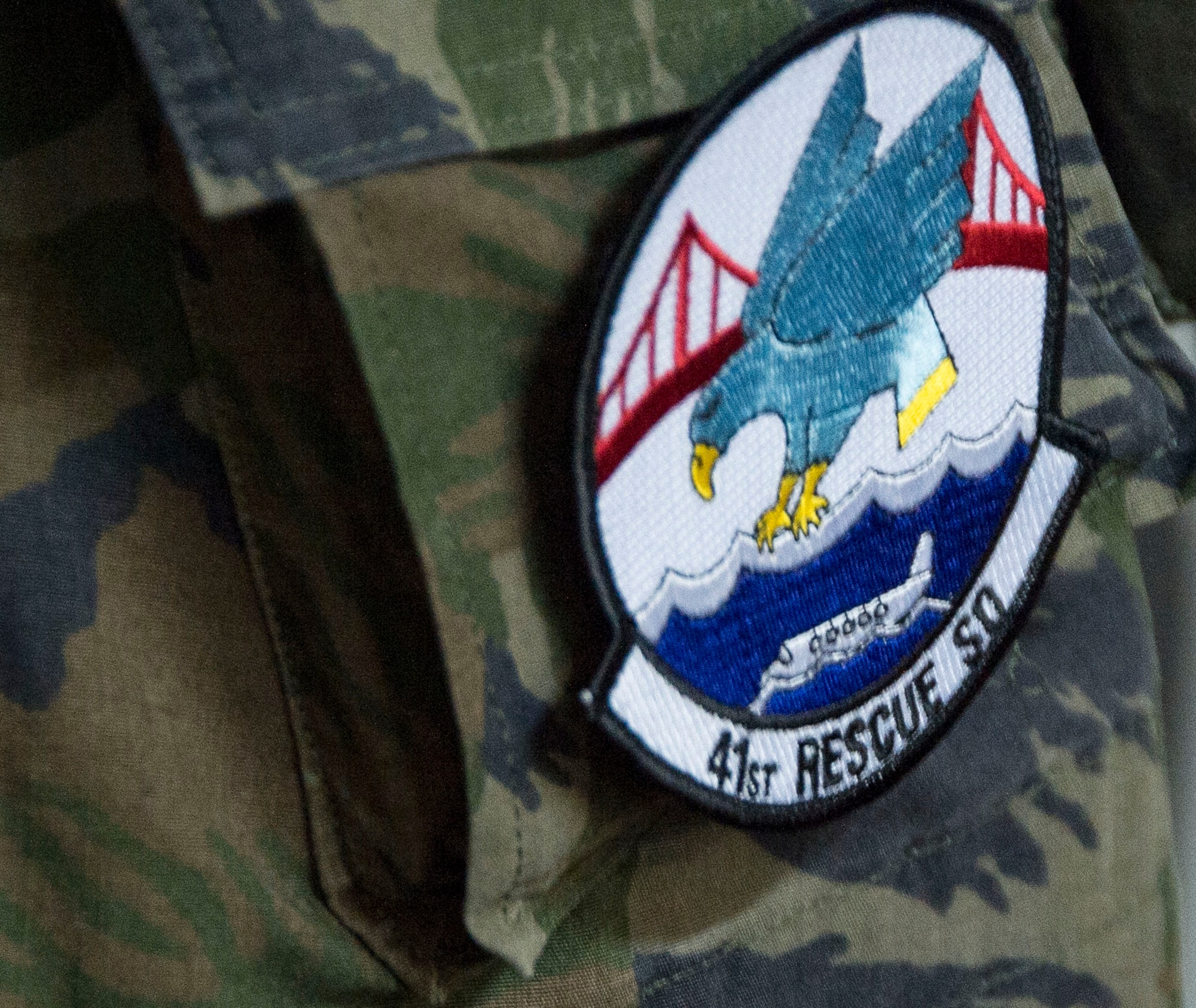 A member of the Brazilian air force wears a patch from the 41st Rescue Squadron after swapping patches with Capt. John Tucciarone, 41st Rescue Squadron HH-60 helicopter pilot, on May 12, 2015 in Campo Grande, Brazil. During the week long exchange Tucciarone spoke to the capabilities of the HH-60 Pavehawk helicopter and its role in Search and Rescue. (U.S. Air Force photo by Staff Sgt. Adam Grant/Released)