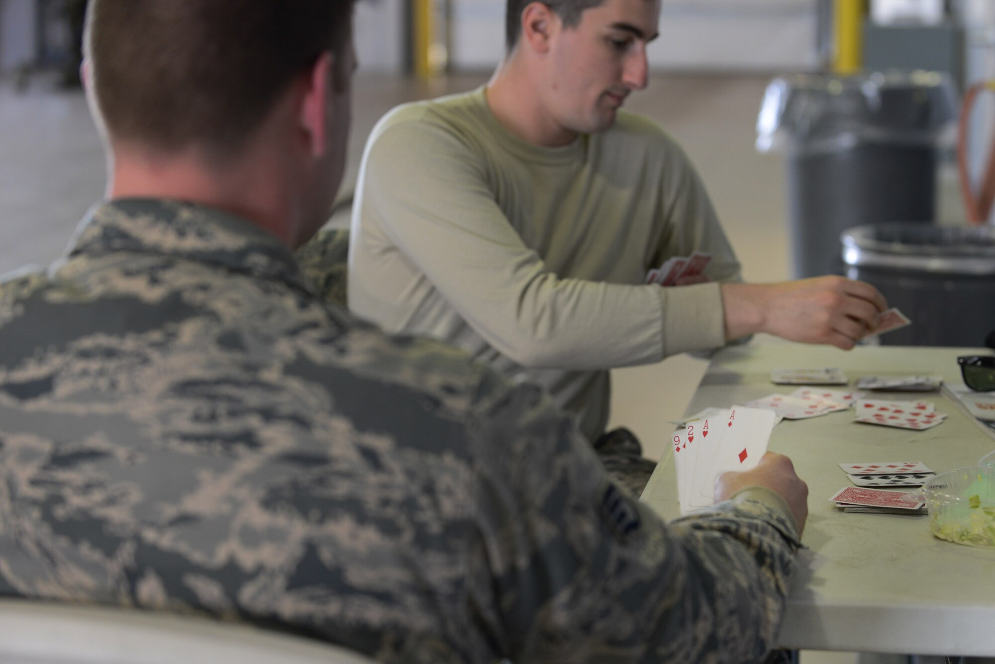 U.S. Air Force Staff Sgt. Ryan Brooks and Senior Airman Robert Horton, 773rd Logistics Readiness Squadron combat mobility technicians, play a game of rummy in-between cargo inspections May 14, 2015, during RED FLAG-Alaska (RF-A) 15-2 at Eielson Air Force Base, Alaska. Brooks and Horton were on temporary duty from Joint Base Elmendorf-Richardson and assisted the 354th LRS air terminal operations section to ensure cargo was accurately processed. (U.S. Air Force photo by Senior Airman Ashley Nicole Taylor/Released)