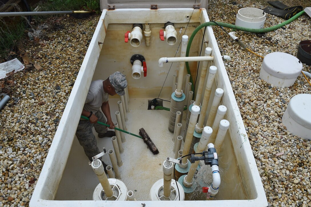Tech. Sgt. Andrew Maramag, 11th Civil Engineer Squadron water fuel system maintenance craftsman, cleans debris out of the sanitary pit for the base pool and splash park at Joint Base Andrews, Md., May 19, 2015. CES Airmen clean in preparation for the base pool’s slated opening of May 23. (U.S. Air Force photo/Senior Airman Joshua R. M. Dewberry) 