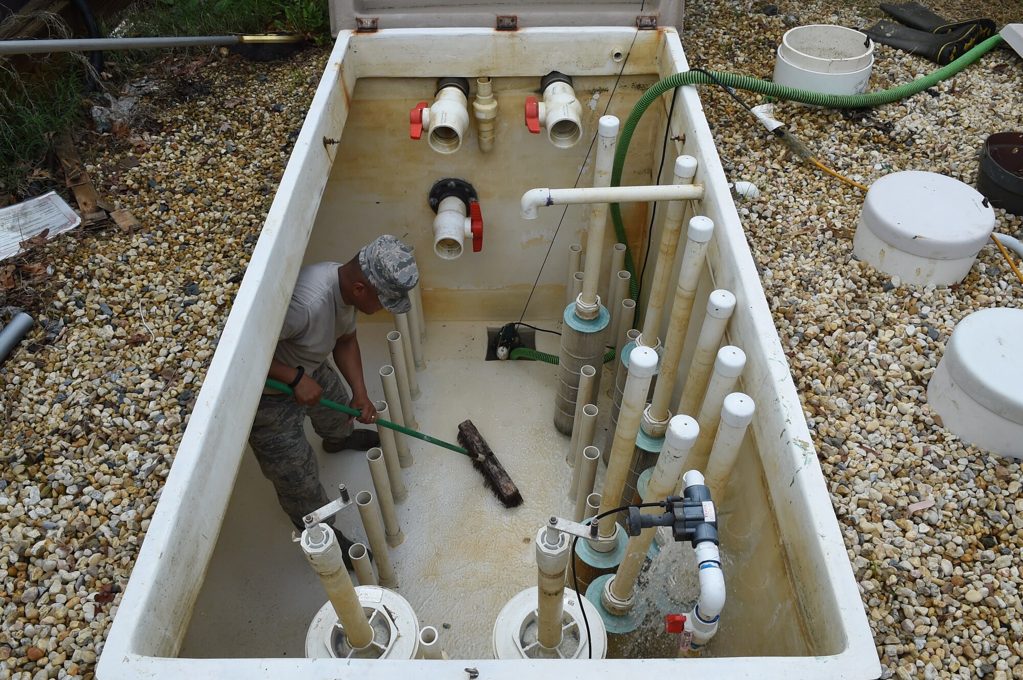 Tech. Sgt. Andrew Maramag, 11th Civil Engineer Squadron water fuel system maintenance craftsman, cleans debris out of the sanitary pit for the base pool and splash park at Joint Base Andrews, Md., May 19, 2015. CES Airmen clean in preparation for the base pool’s slated opening of May 23. (U.S. Air Force photo/Senior Airman Joshua R. M. Dewberry) 