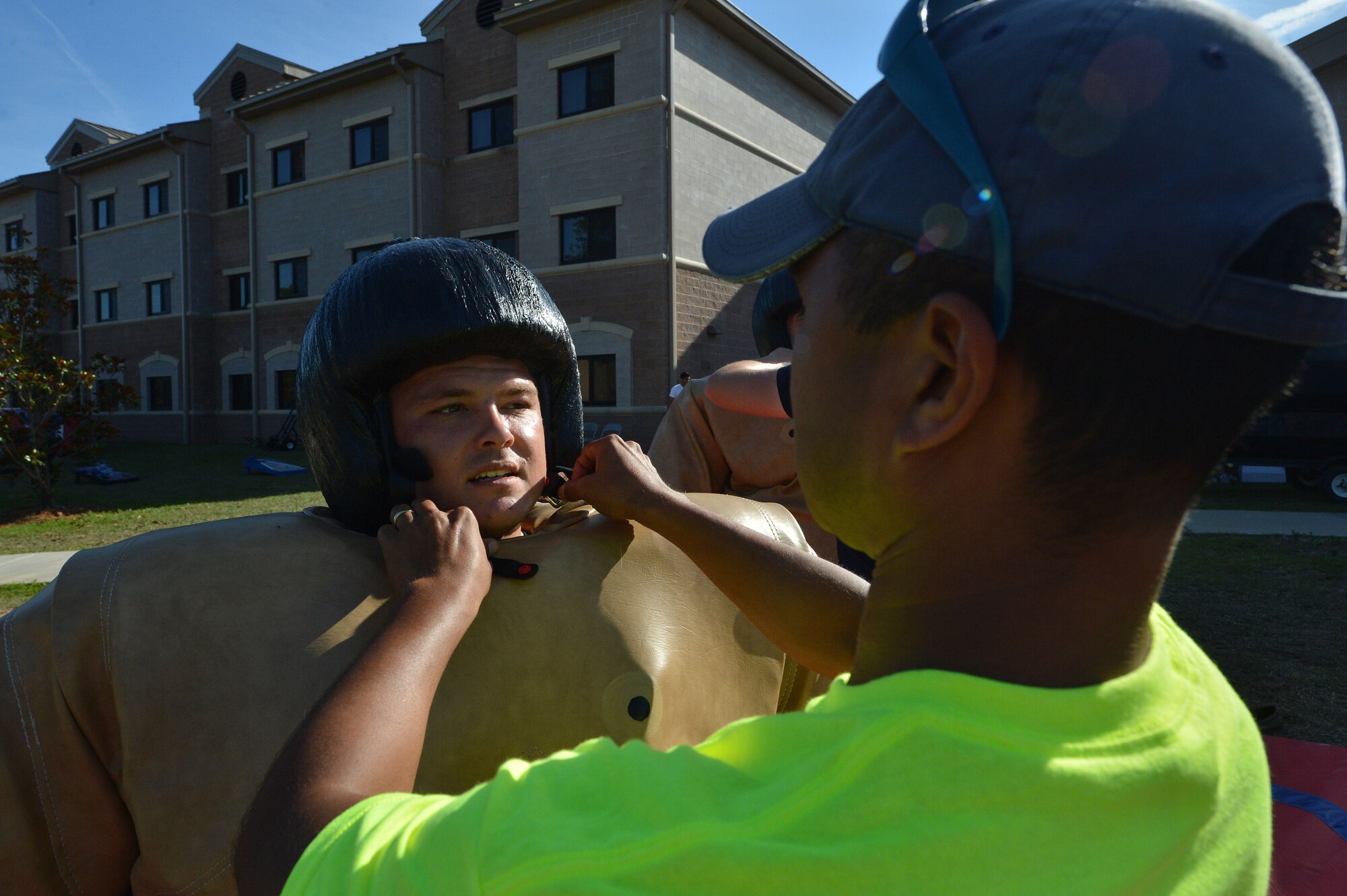 U.S. Air Force Chaplain (Capt.) Robert Pitts, 20th Fighter Wing chaplain, puts a sumo helmet on a Team Shaw member during a base-wide block party at Shaw Air Force Base, S.C., May 17, 2015. The block party took place at seven locations around base. (U.S. Air Force photo by Airman 1st Class Michael Cossaboom/Released)