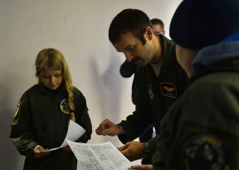 U.S. Air Force Capt. Jason Ford, 871st Air Expeditionary Squadron F-15C Eagle fighter aircraft pilot, gives a simulated mission brief to Arna Tryggvadóttir and Gunnar Guðlaugsson during the Pilot for a Day program at Keflavik International Airport, Iceland, May 13, 2015.The program allowed two terminally ill Icelandic children to experience a day in the life of a U.S. Air Force pilot. (U.S. Air Force photo by 2nd Lt. Meredith Mulvihill/Released)
