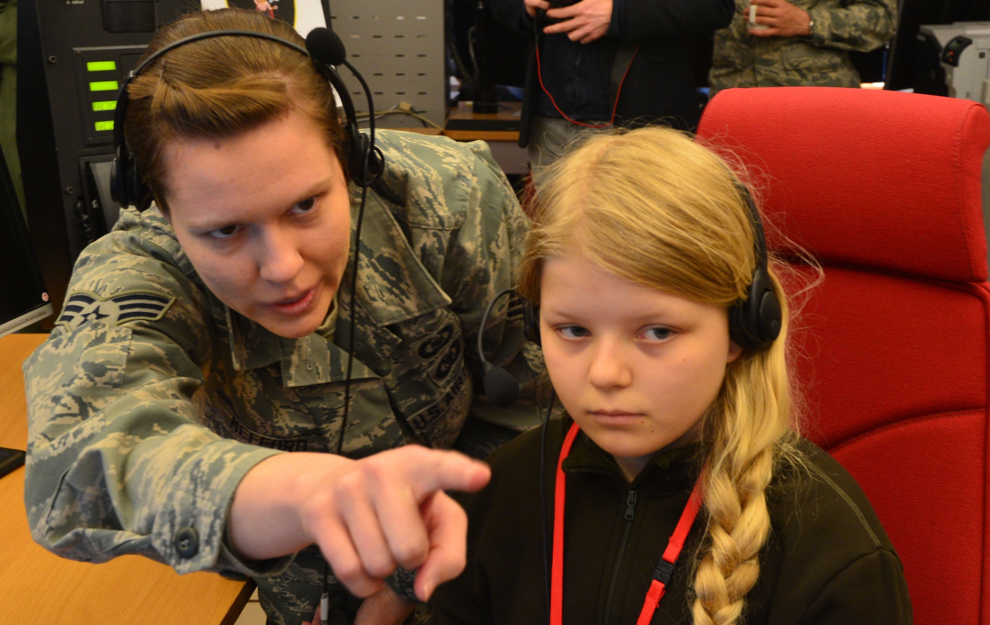 U.S. Air Force Senior Airman Jessica Mefford, 871st Air Expeditionary Squadron, shows Arna Tryggvadóttir, Pilot for a Day participant, how to operate systems at the Control and Reporting Center during the program at Keflavik International Airport, Iceland, May 13, 2015. As part of the program, both children toured the CRC and participated in a simulated mission. (U.S. Air Force photo by 2nd Lt. Meredith Mulvihill/Released)