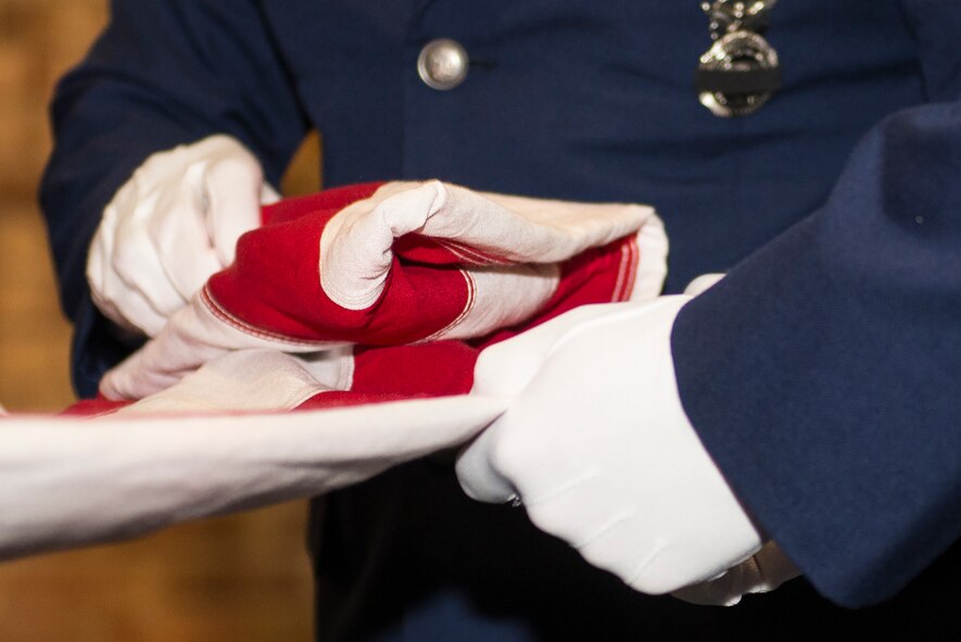 U.S. Air Force Tech. Sgt. Jamaal Smalls, 23d Security Forces Squadron flight chief, left, and Airman Ryan Powell, 23d SFS gate guard, fold the flag during the 2015 National Police Week Memorial Ceremony May 15, 2015, at Moody Air Force Base, Ga. President John F. Kennedy signed a proclamation in 1962 which designated May 15 as Police Officers’ Memorial Day. (U.S. Air Force photo by Airman Greg Nash/Released)