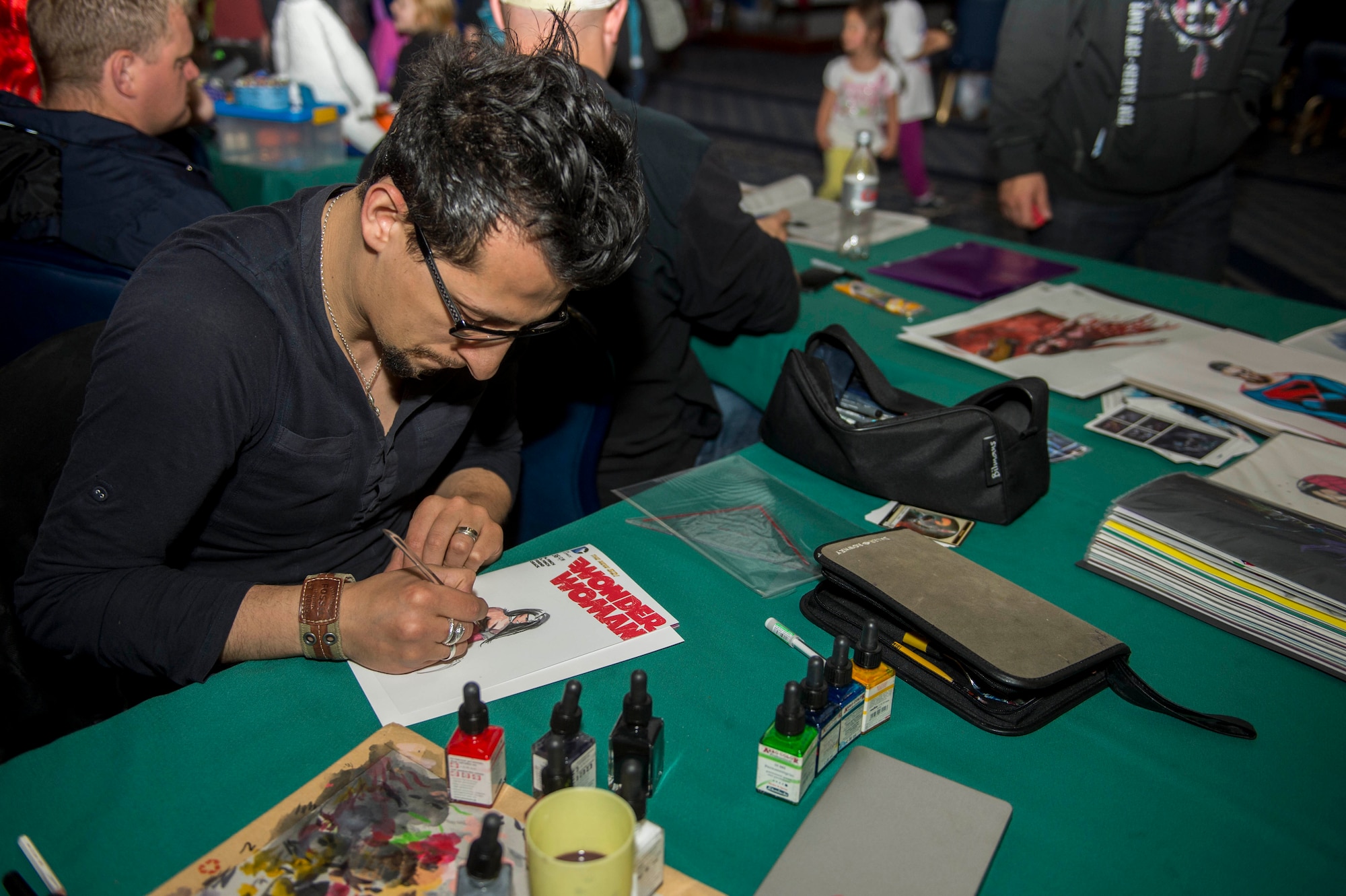 Anthony Darr, a comic book illustrator, showcases his artwork during the 2015 Comic Con at Club Eifel on Spangdahlem Air Base, Germany, May 16, 2015. Darr was one of the many artists present at the convention exhibiting their talents. (U.S. Air Force photo by Airman 1st Class Timothy Kim/Released)