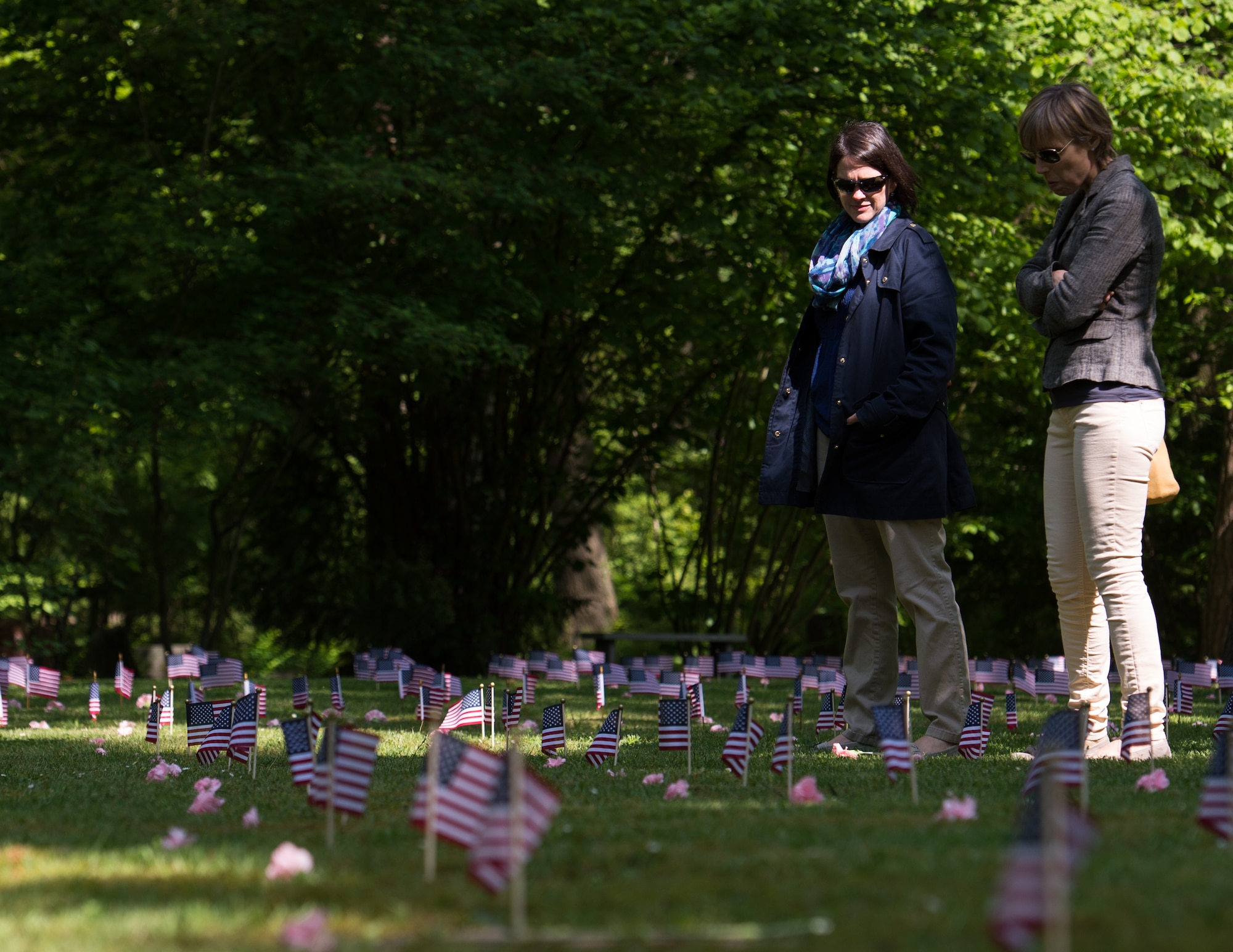 People pay their respects to the 451 fallen children during the Kindergraves memorial service May 16, 2015, in Kaiserslautern, Germany. Children buried here were no more than 12 months old during 1952 to 1971, most died of various childhood diseases or birth complications. Each spring floral wreaths are placed at the front monument along with a candle lighting ceremony in memory of the children, as well as American flags placed at each grave marker. (U.S. Air Force photo/Senior Airman Jonathan Stefanko)