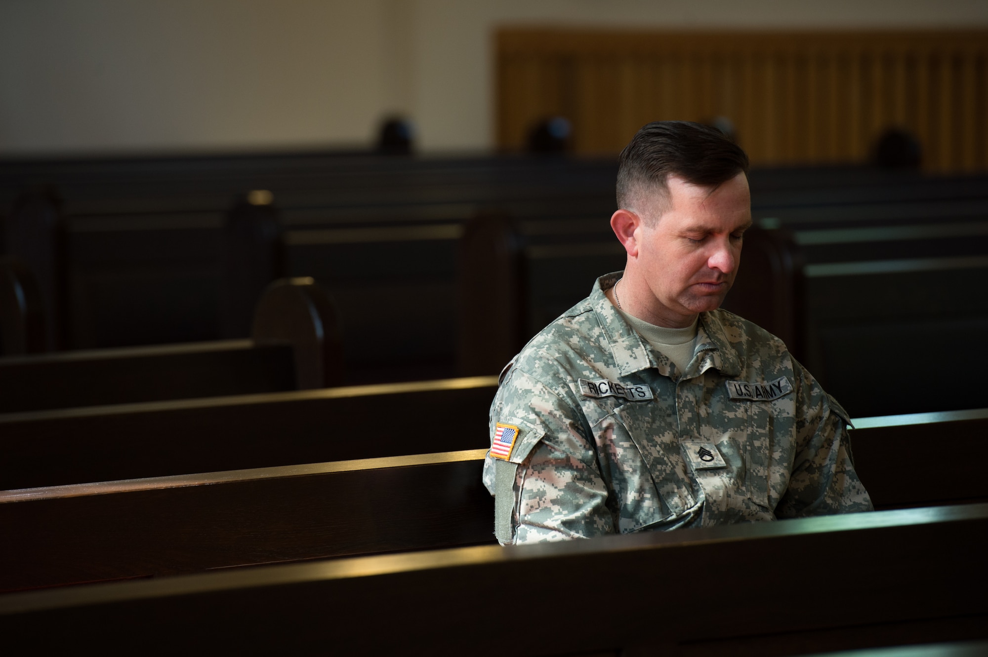 U.S. Army Staff Sergeant Wesley Ricketts, 7th Civil Support Squadron, pays his respects during the Kindergraves memorial service May 16, 2015, in Kaiserslautern, Germany. Children buried here died at birth of shortly after birth from 1952 to 1971; most of the children died of various diseases or due to birth complications. Each spring floral wreaths are placed at the front monument along with a candle lighting ceremony in memory of the children. Also, American flags are placed at each grave marker. (U.S. Air Force photo/Senior Airman Jonathan Stefanko)
