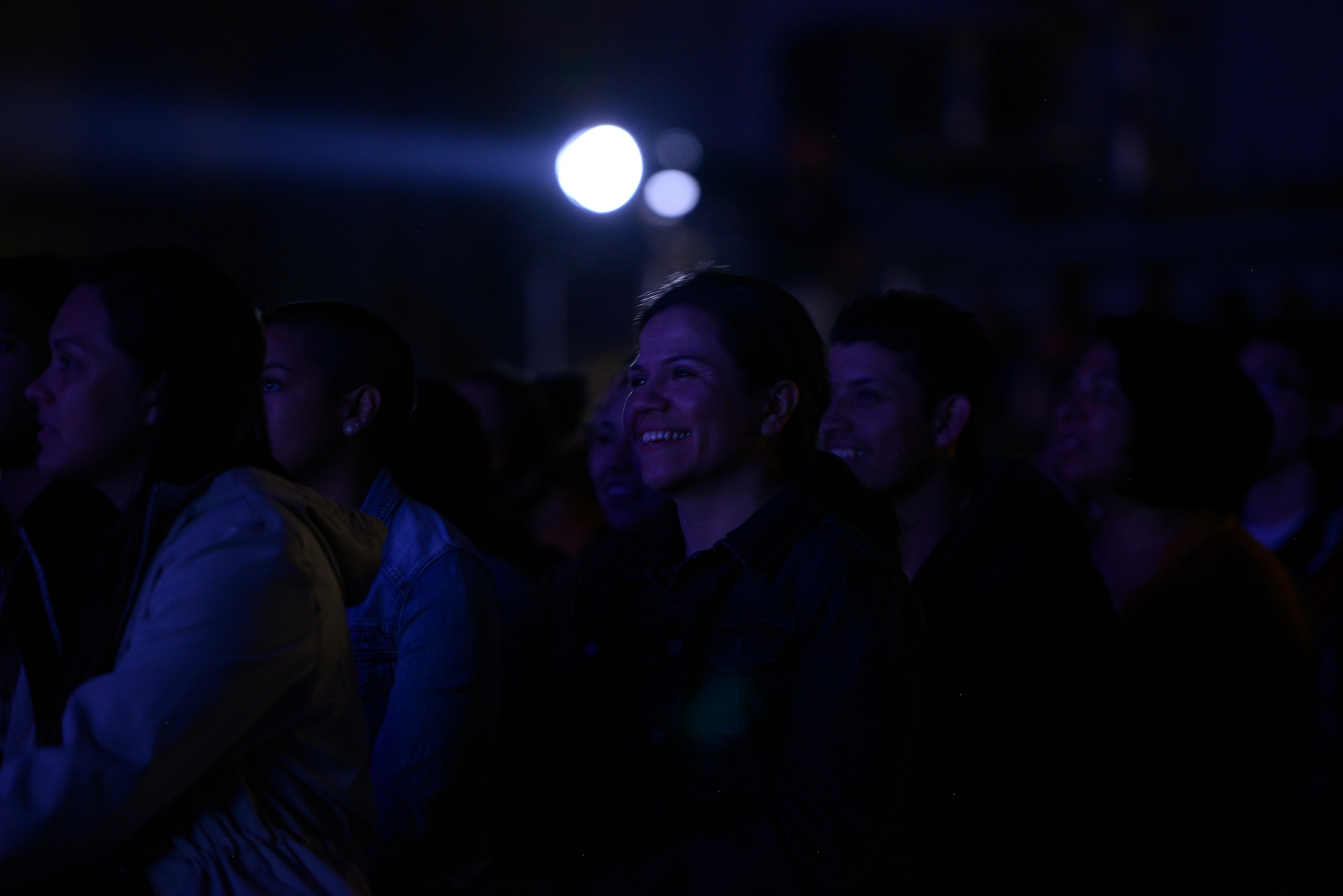 Airmen and their family members watch as George Lopez, a comedian, actor and talk show host, entertains a crowd by performing his comedy routine for an Armed Forces Entertainment event at Ramstein Air Base, Germany, May 16, 2015. The free event was held in appreciation for military members and their families. (U.S. Air Force photo/Staff Sgt. Kris Levasseur)
