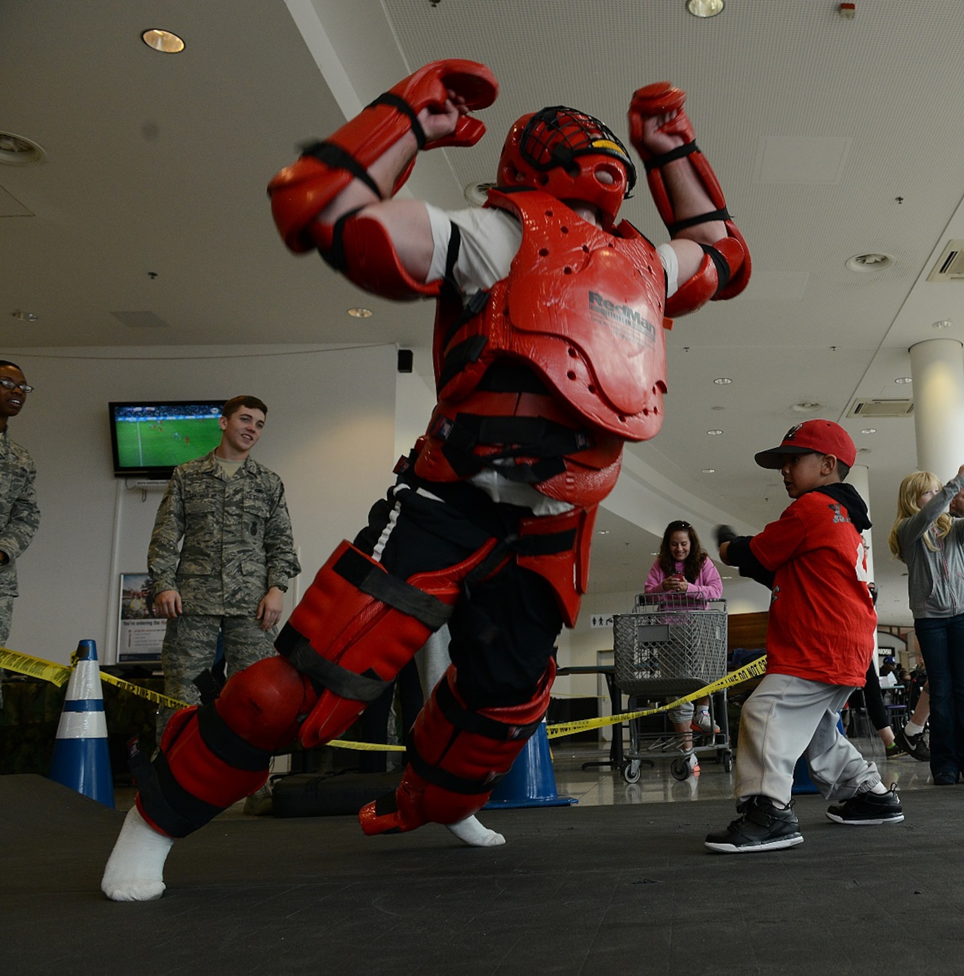 A security forces Airman teaches a child hands-on self-defense during a display held in honor of National Police Week May 9, 2015, at Ramstein Air Base, Germany. Each participant was allowed two rounds with the opponent. (U.S. Air Force photo/Airman 1st Class Tryphena Mayhugh)