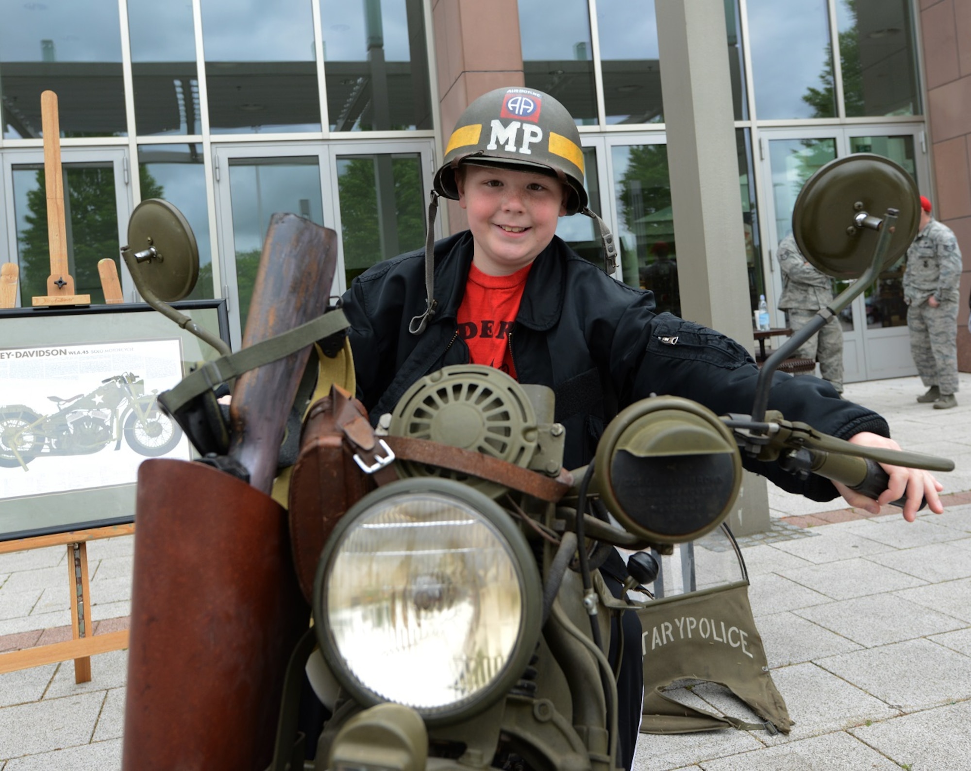 A child sits on a vintage military police motorcycle during a display held in honor of National Police Week May 9, 2015, at Ramstein Air Base, Germany. Patrons were also able to sit in police cars and a Max Pro mine-resistant ambush-protected vehicle during the event. (U.S. Air Force photo/Airman 1st Class Tryphena Mayhugh)