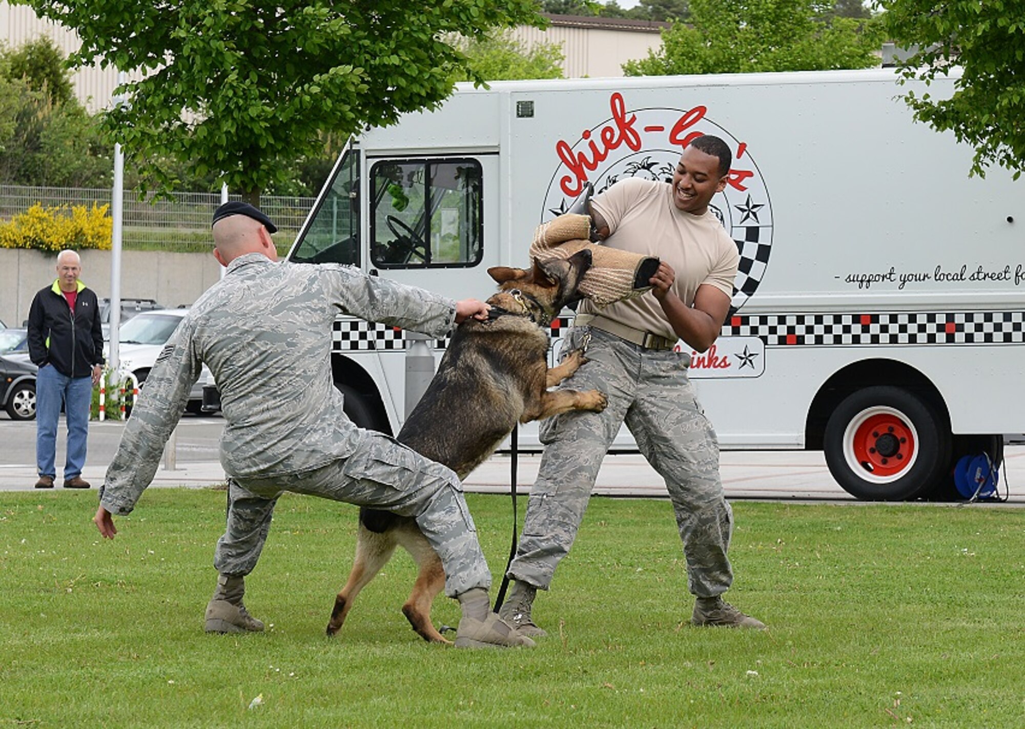 Staff Sgt. Chad Coe, 86th Security Forces Squadron military working dog handler, tries to pry off Charone, 86th SFS MWD, from a “perpetrator” during a MWD demonstration May 9, 2015, at Ramstein Air Base, Germany. The demonstration was a part of a display held at the Kaiserslautern Military Community Center in honor of National Police Week. (U.S. Air Force photo/Airman 1st Class Tryphena Mayhugh)