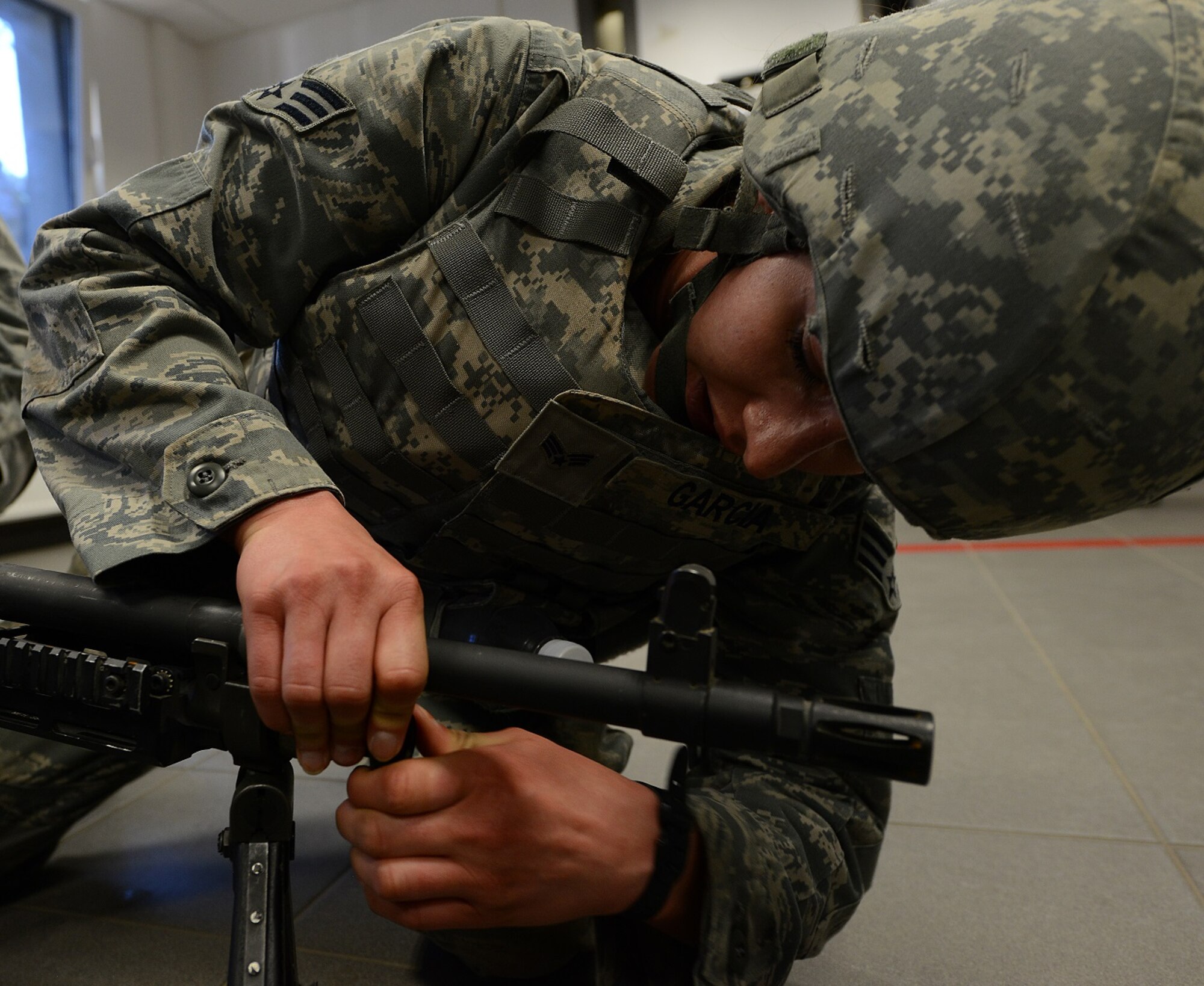 An Airman from the 86th Security Forces Squadron works to disassemble and reassemble a weapon as part of the Battle of the Badges competition May 14, 2015, at Vogelweh Military Complex, Germany. The competition was held in honor of National Police Week. (U.S. Air Force photo/Airman 1st Class Tryphena Mayhugh)