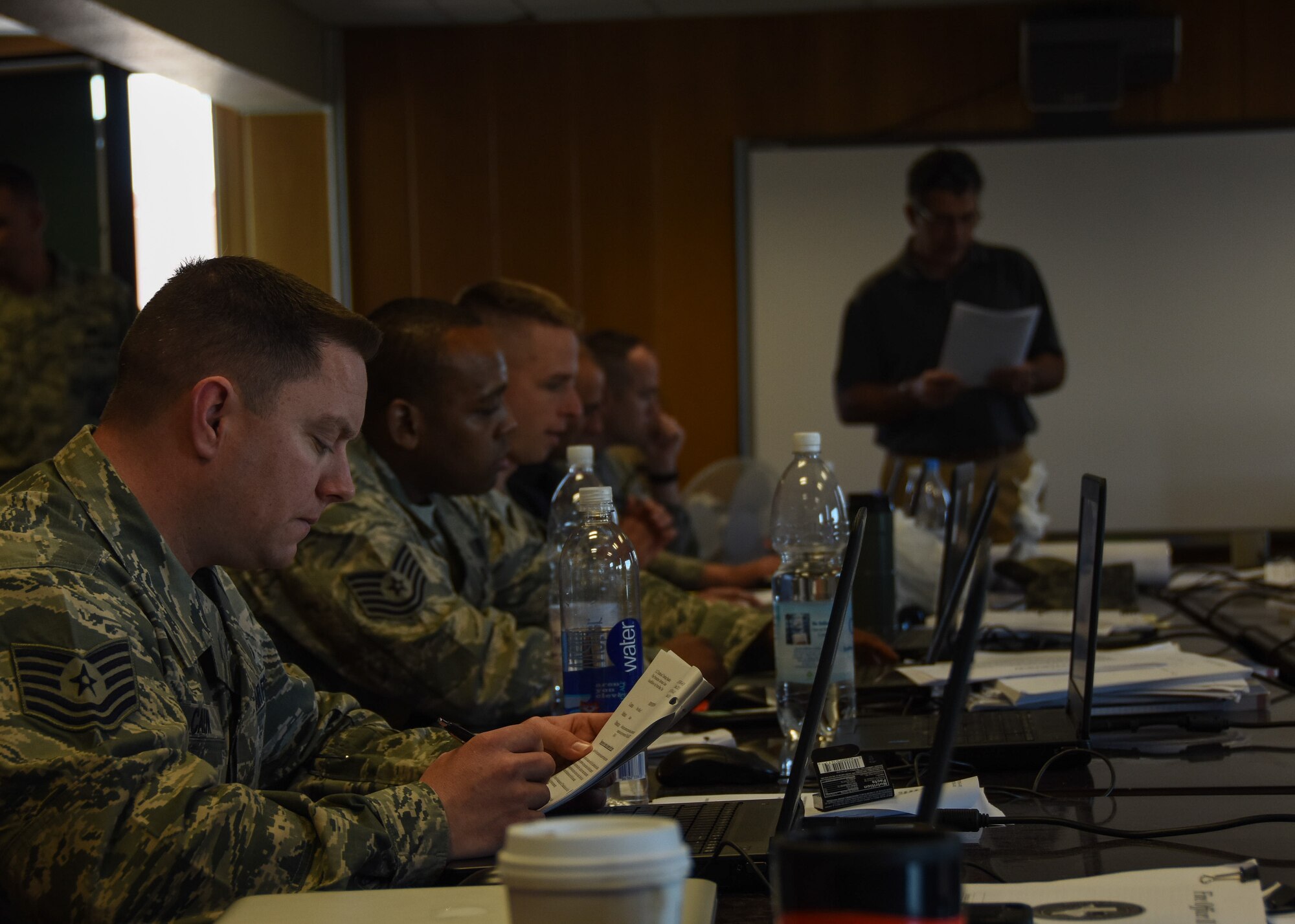 Airmen look at their course handouts as Michael DeJacomo, a mobile training team instructor with the 312th Training Squadron, conducts a lecture during a Fire Officer III certification course May 13, 2015 at Ramstein Air Base. Eighteen firefighters from across U.S. Air Forces in Europe gathered here for the 10-day advanced fire protection course which began May 4, 2015. (U.S. Air Force photo by Staff Sgt. Jonathan Hehnly/Released)
