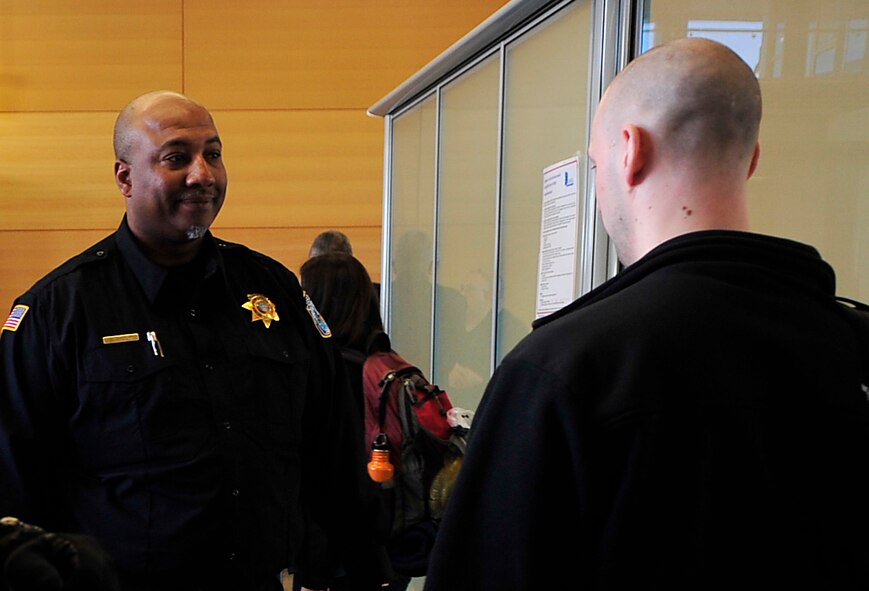 Fortunet Wilson, U.S. Army Customs Europe customs inspector, asks an inbound passenger questions about customs claims in the Ramstein Passenger Terminal April 14, 2015, at Ramstein Air Base, Germany. Customs members at the terminal have many jobs such as checking cargo, directing traffic and safeguarding the environment and people. (U.S. Air Force photo/Airman 1st Class Larissa Greatwood)