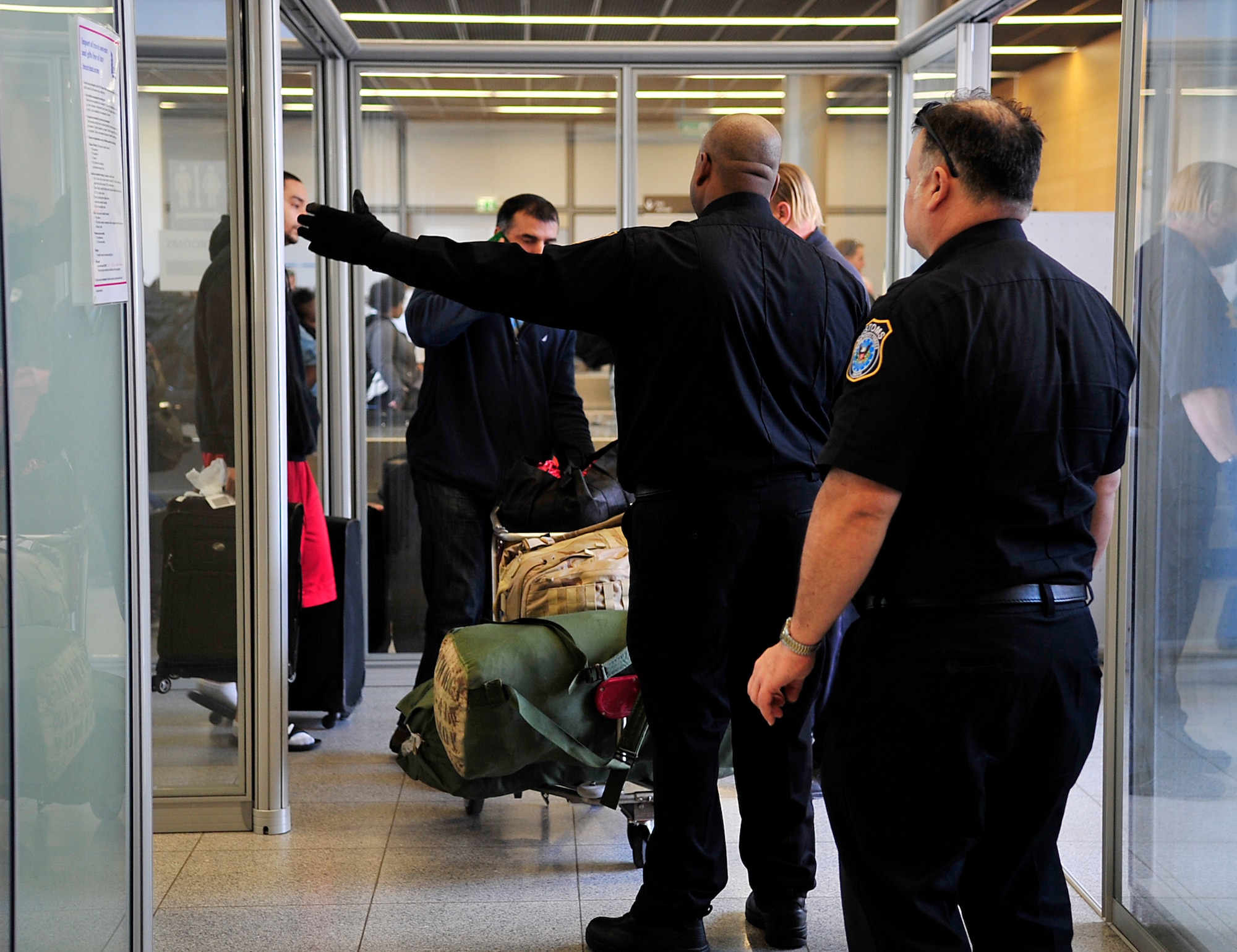 Fortunet Wilson, U.S. Army Customs Europe customs inspector, directs inbound passengers in the Ramstein Passenger Terminal April 14, 2015, at Ramstein Air Base, Germany. Customs members at the  terminal have many jobs such as checking cargo, directing traffic and safeguarding the environment and people. (U.S. Air Force photo/Airman 1st Class Larissa Greatwood)