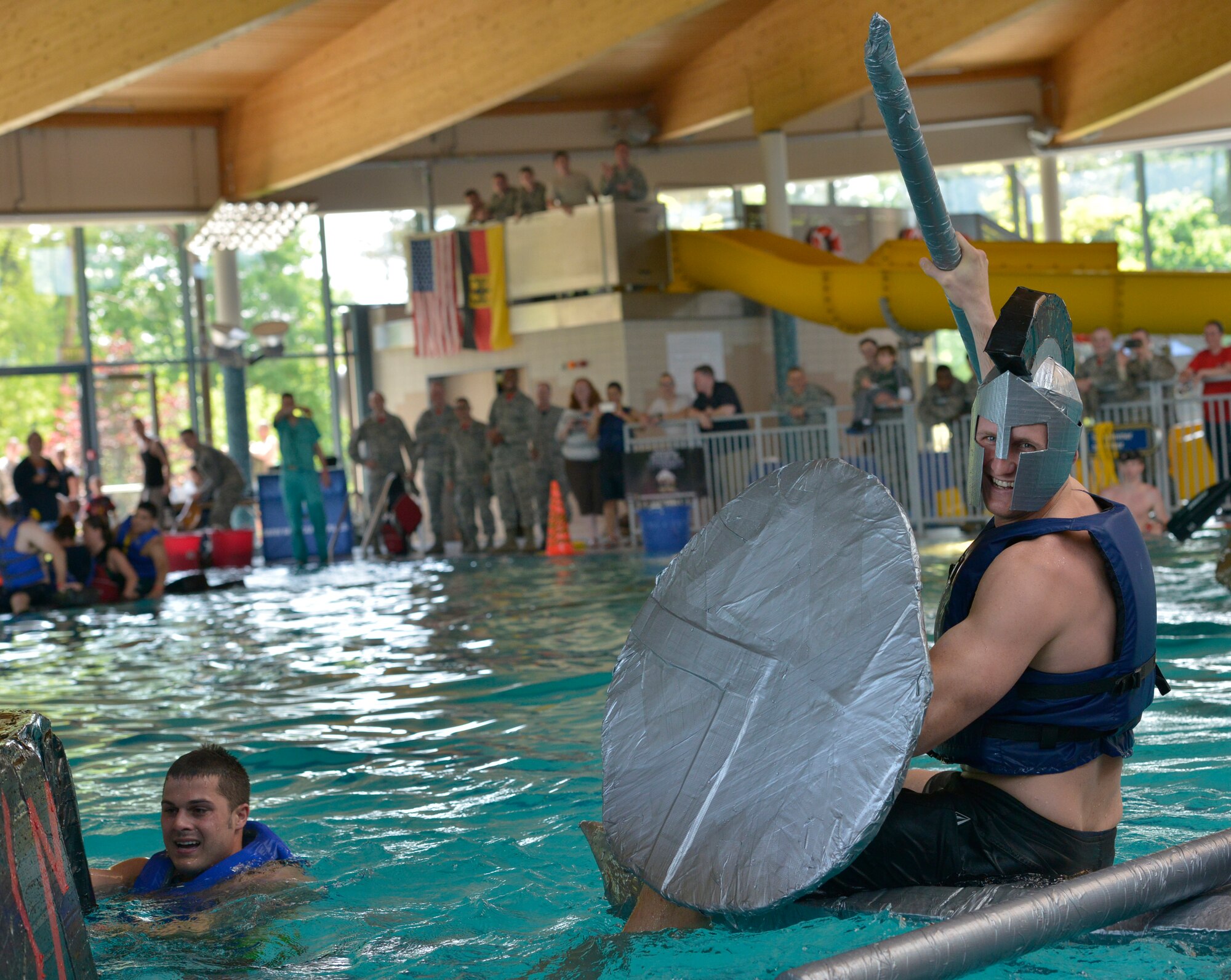 A participant celebrates emerging victorious from a battle with a rival boat during the Battle of the Battleships competition May 15, 2015, at Ramstein Air Base, Germany. After racing each other, the participating teams were thrown together for the final challenge of fighting until the last boat was sunk. (U.S. Air Force photo by Airman 1st Class Lane T. Plummer/Released)