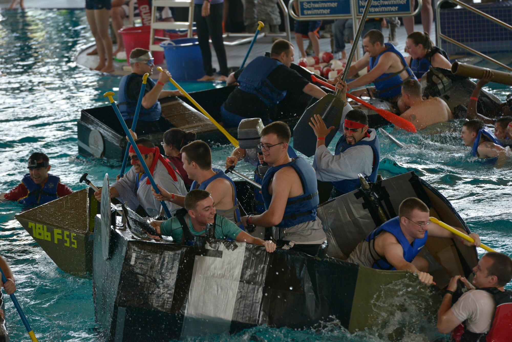 Competitors attack other boats during the Battle of the Battleships competition May 15, 2015, at Ramstein Air Base, Germany. After racing their boats, whatever was still afloat participated in a free-for-all battle. (U.S. Air Force photo by Airman 1st Class Lane T. Plummer/Released)