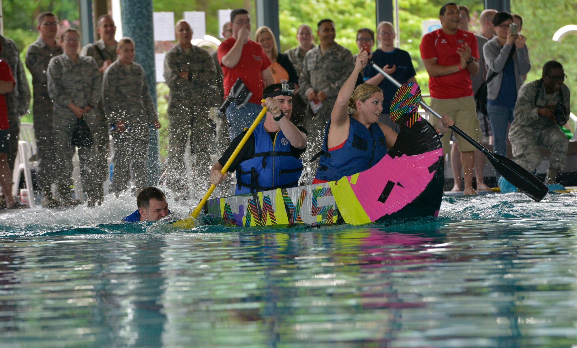 Participants race during the Battle of the Battleships competition May 15, 2015, at Ramstein Air Base, Germany. The competition began with boat races, where several homemade boats were pedaled from one end of the center’s pool to the other by the teams who built them. (U.S. Air Force photo by Airman 1st Class Lane T. Plummer/Released)