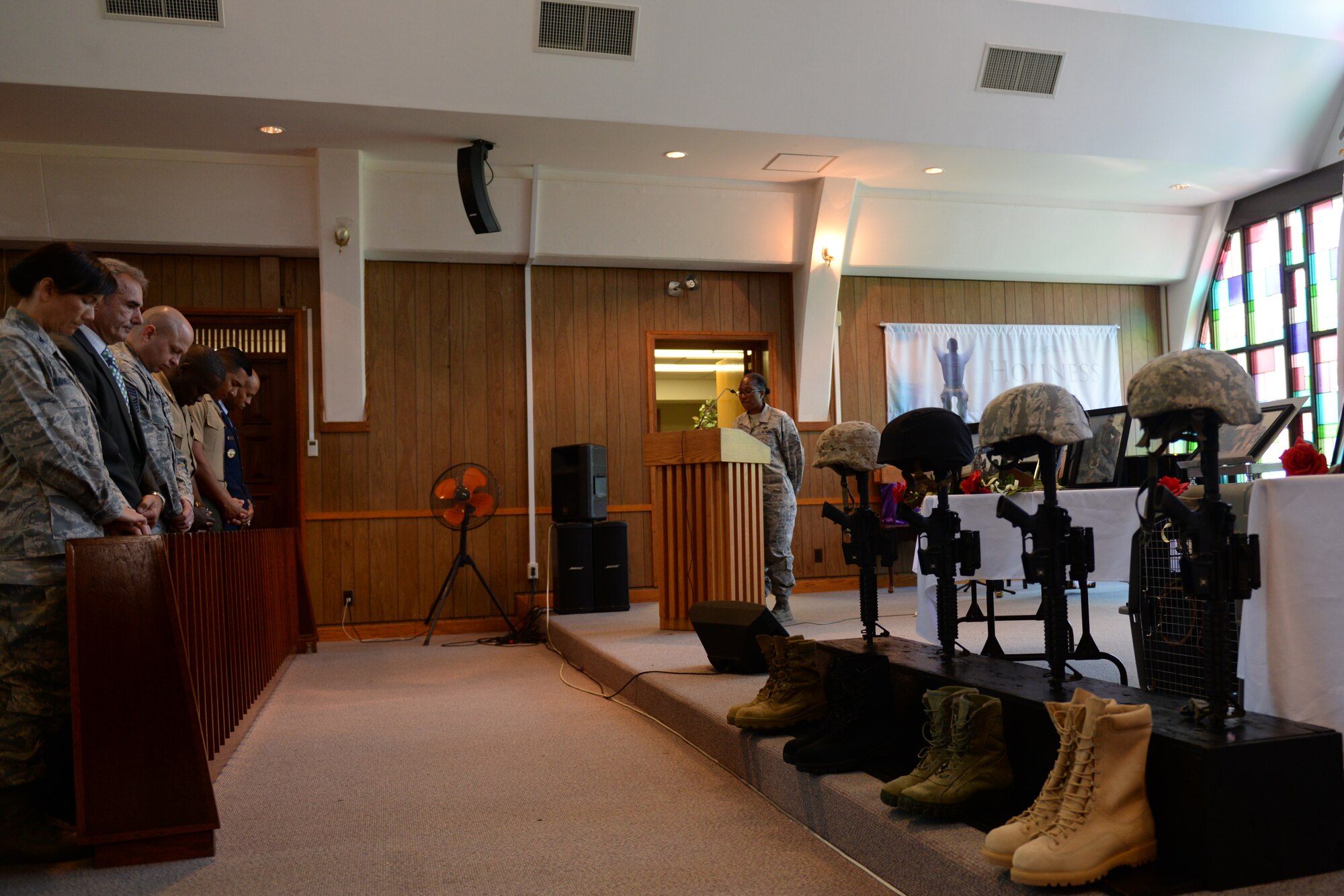 Service members and civilians bow their heads for a moment of silence in honor of fallen police officers during National Police Week on Kadena Air Base, Japan, May 15, 2015. The memorial service paid tribute to military law enforcement personnel that died in the line of duty. (U.S. Air Force photo 5by Senior Airman Omari Bernard)